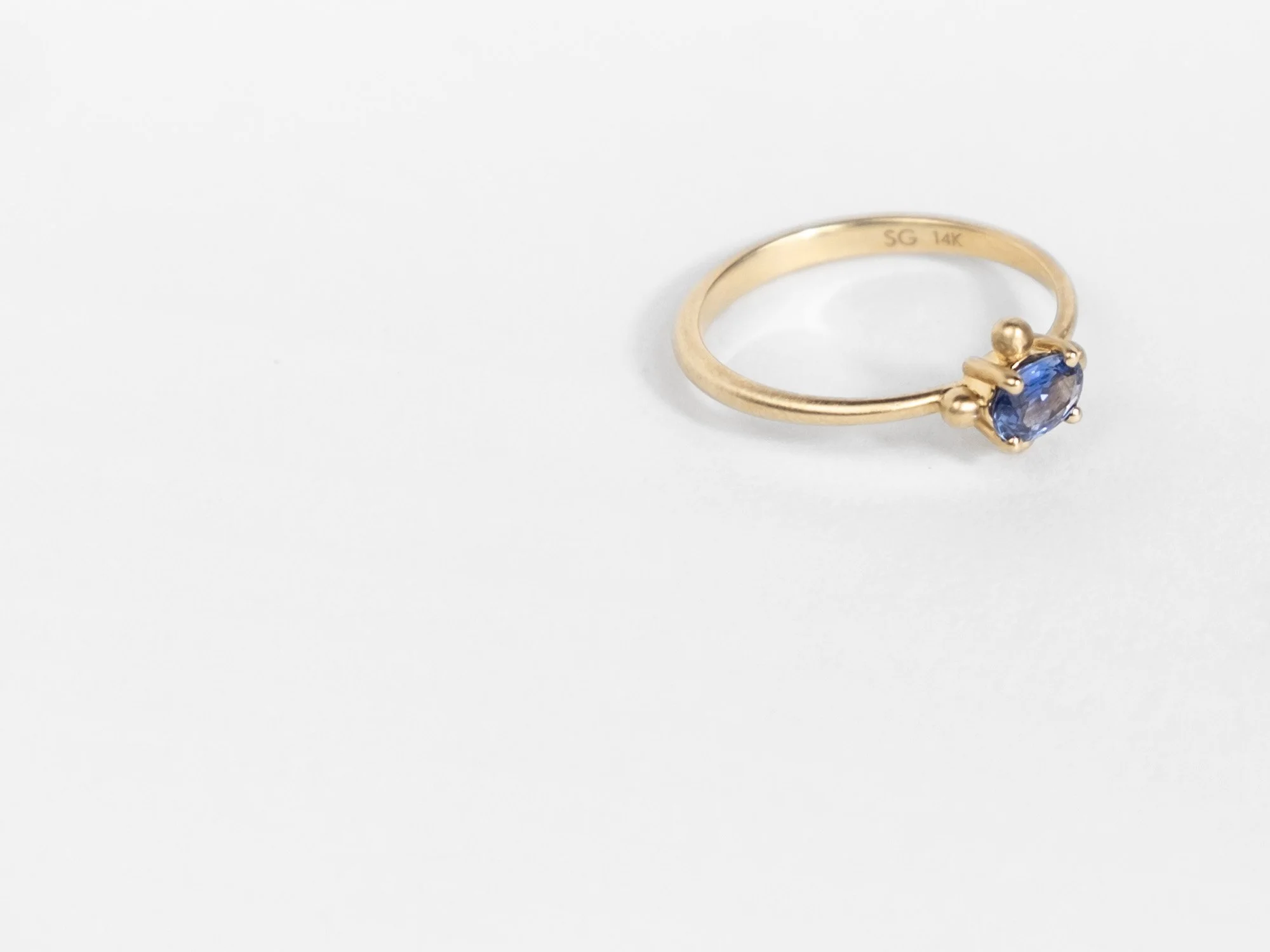 14k gold ring with a center purple-blue oval-shaped sapphire by Sara Golden Jewelry