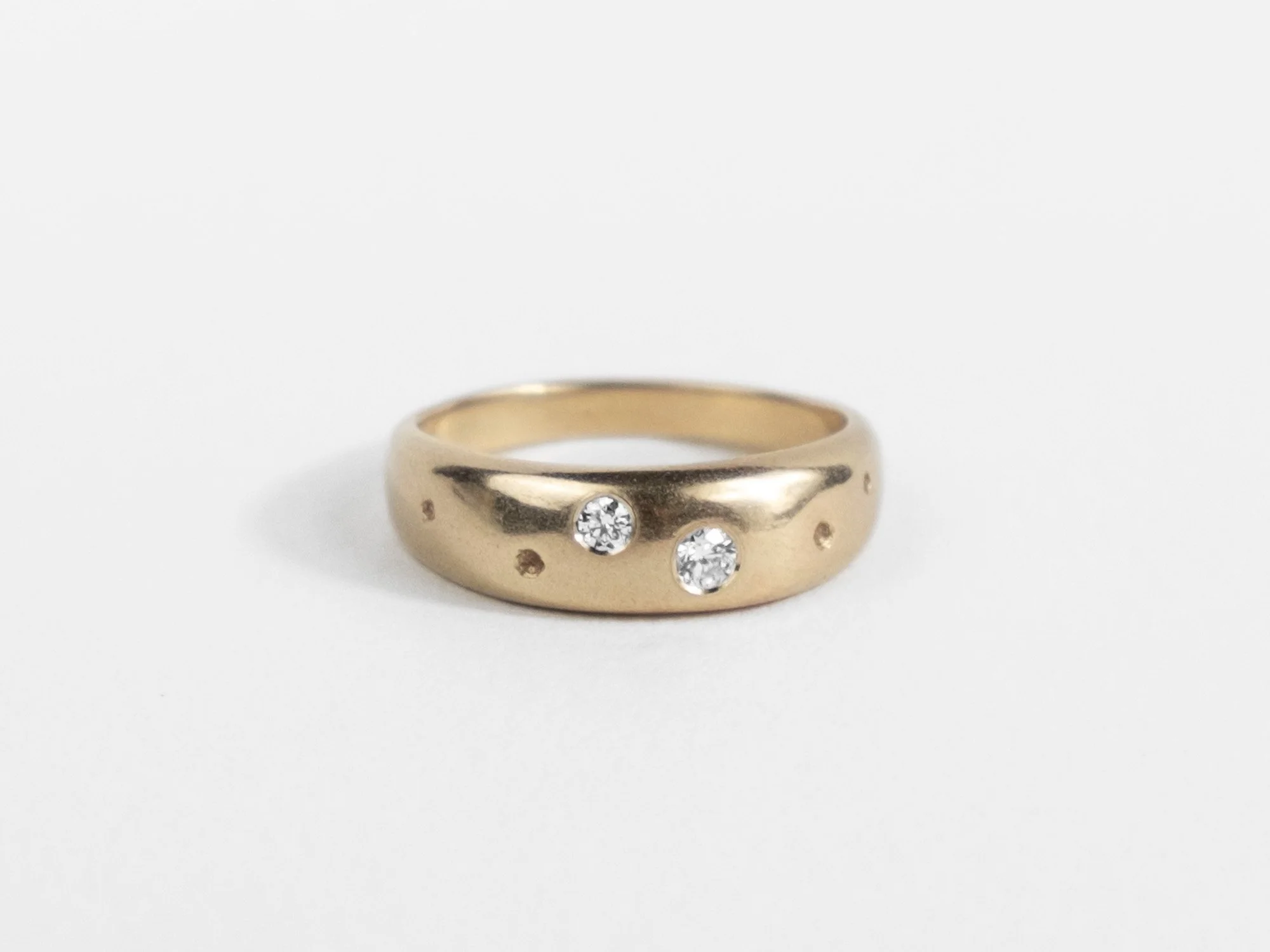 Gold tapered ring dotted with diamonds and small divet