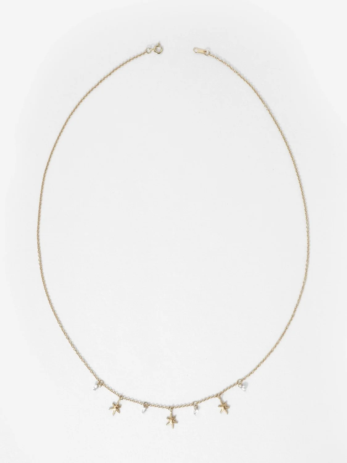 Gold necklace with hanging gold stars and white diamonds