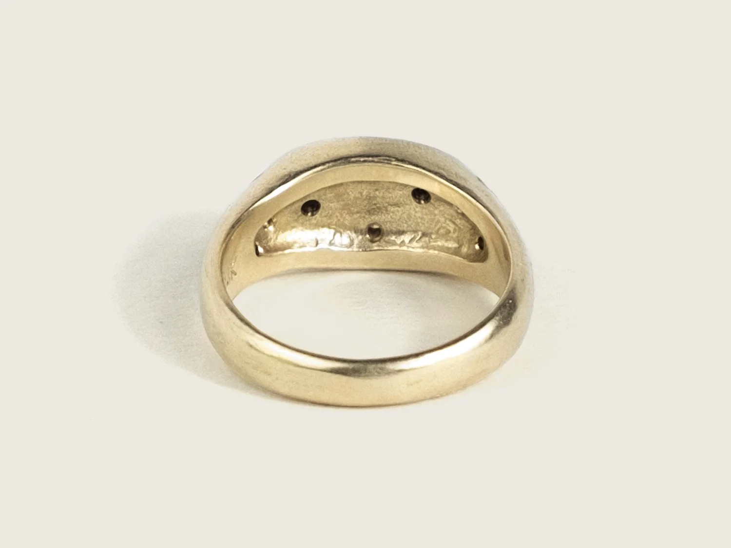 Back view of a wide gold signet ring