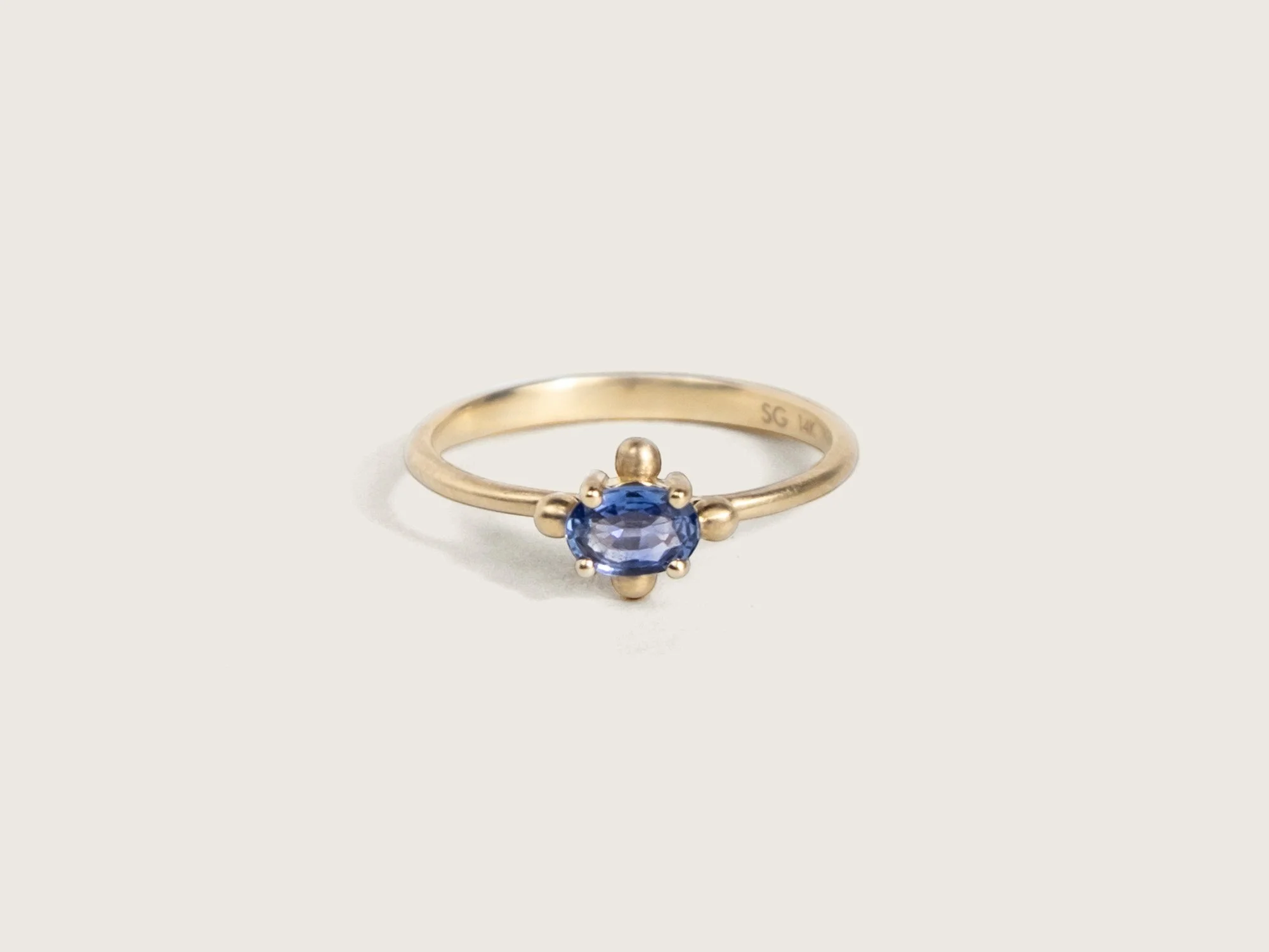 14k gold ring with a center purple-blue oval-shaped sapphire by Sara Golden Jewelry