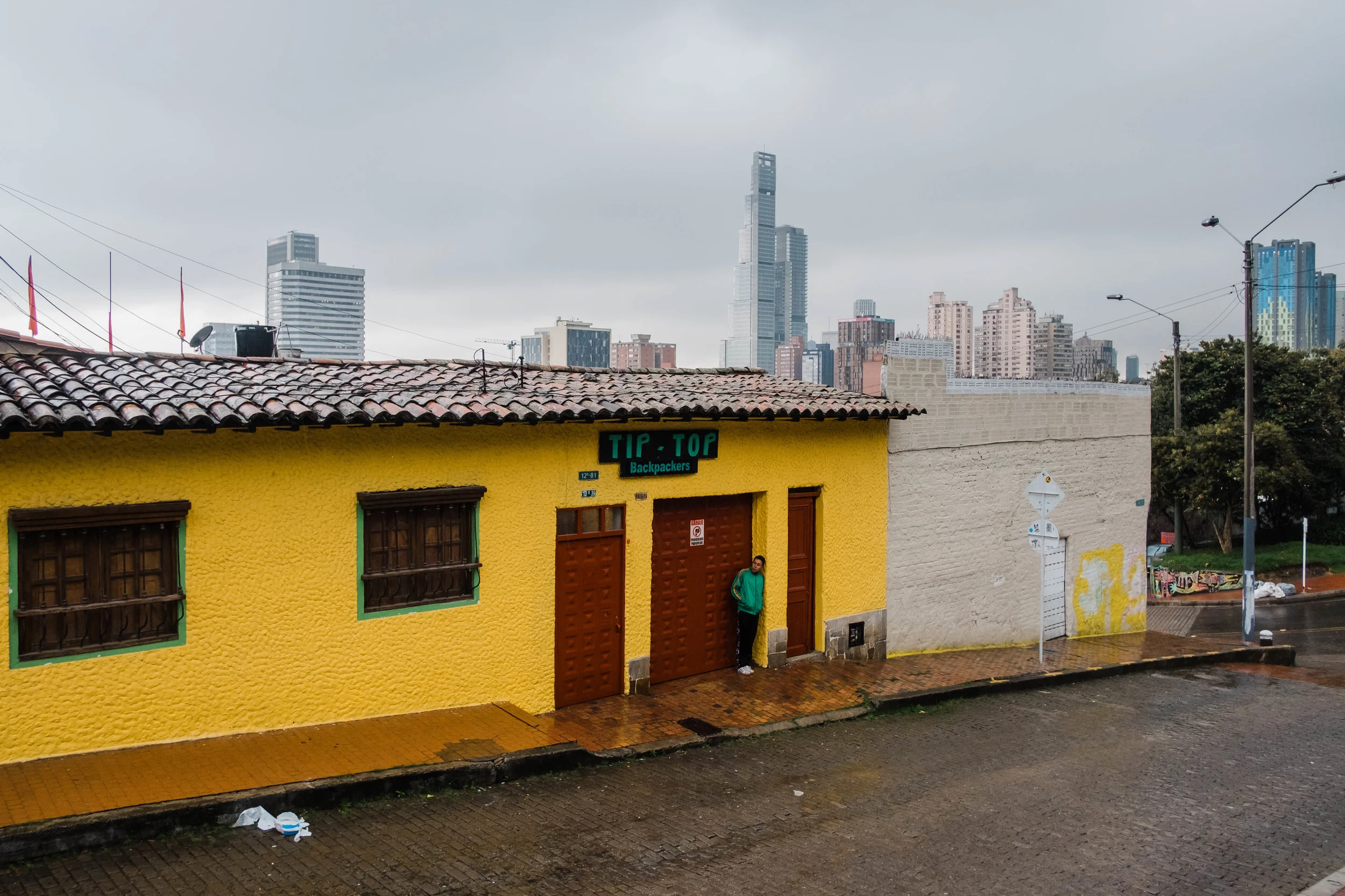 Man watching the outside of a hostel in La Candelaria, Bogota, Colombia.
