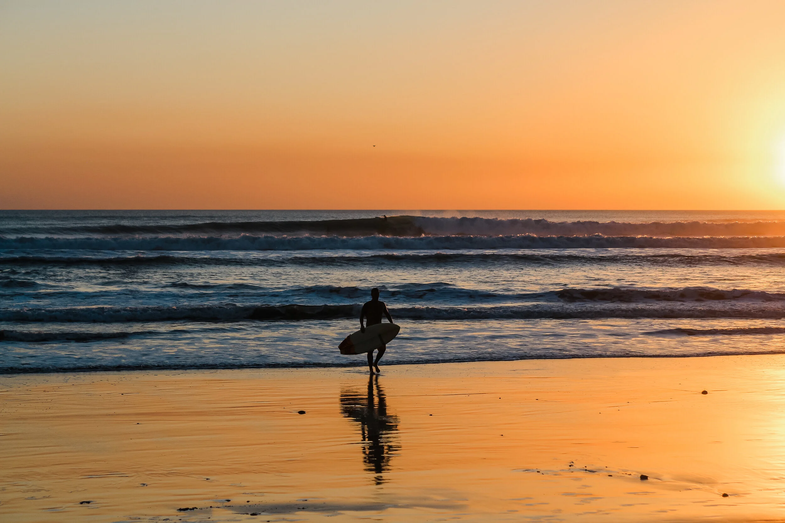 A surfer returns from the open ocean. Santa Teresa, Costa Rica.