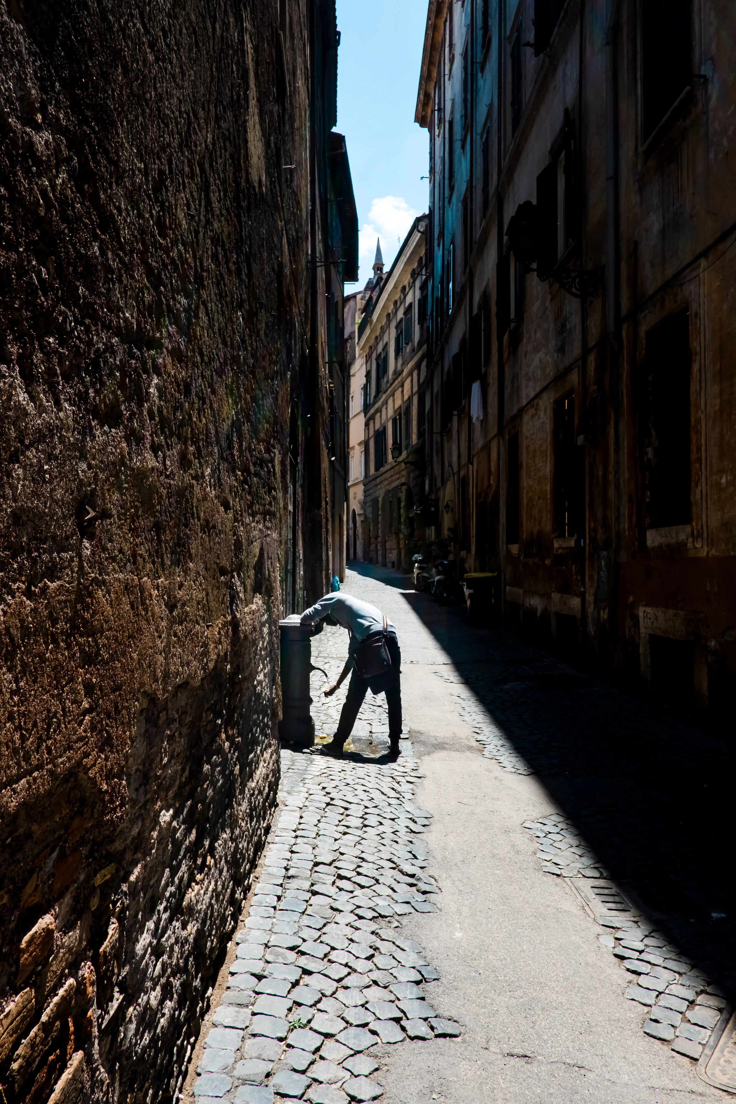 Man drinks from a street fountain, called nasoni, in Rome, Italy.