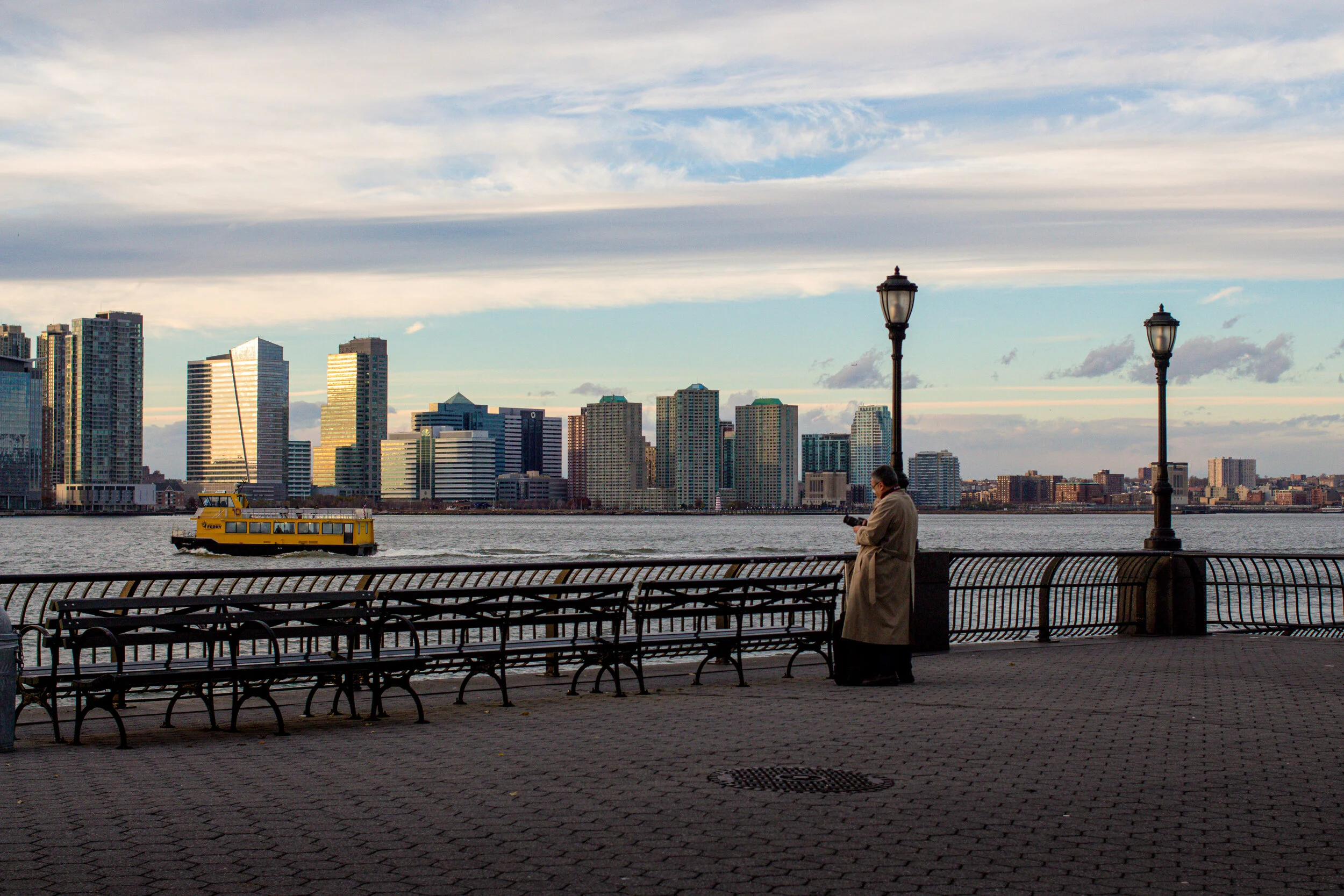 A man photographs at the Hudson River Waterfront Walkway in New York, USA.
