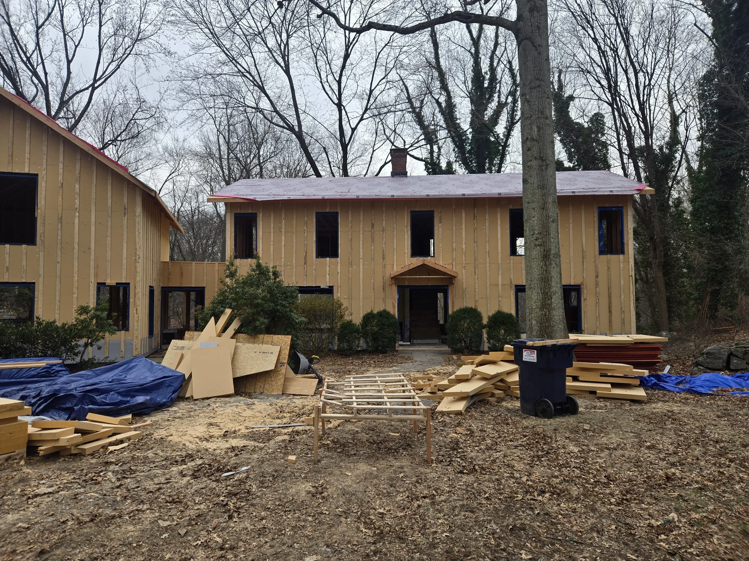 Exterior facade of the West Hill Residence during construction, showing progress on the vertical enlargement.