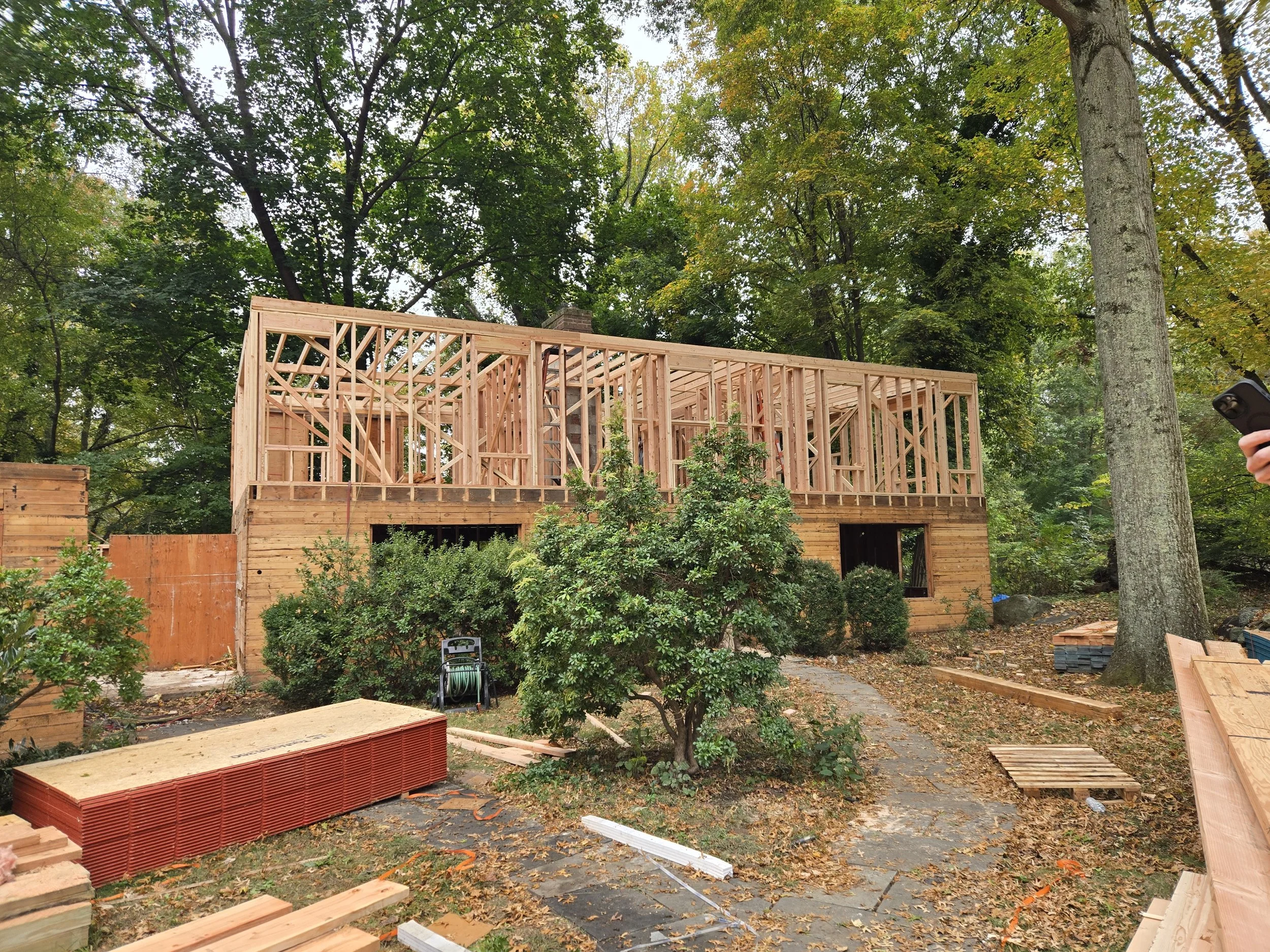 Exterior view of the West Hill Residence during construction, showing second-floor framing in progress.
