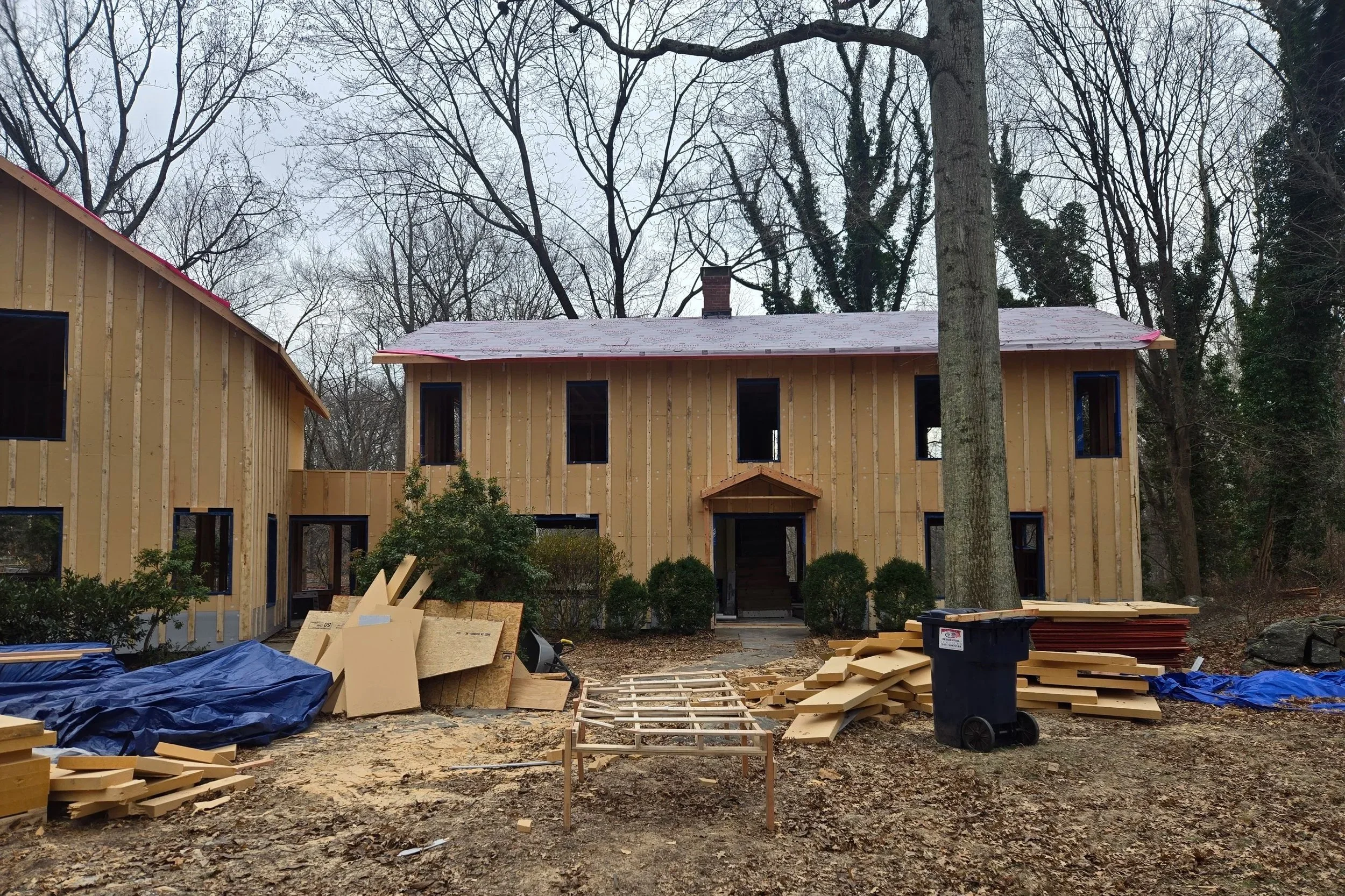 Exterior view of the West Hill Residence during construction, showing the in-progress facade of the vertical enlargement.
