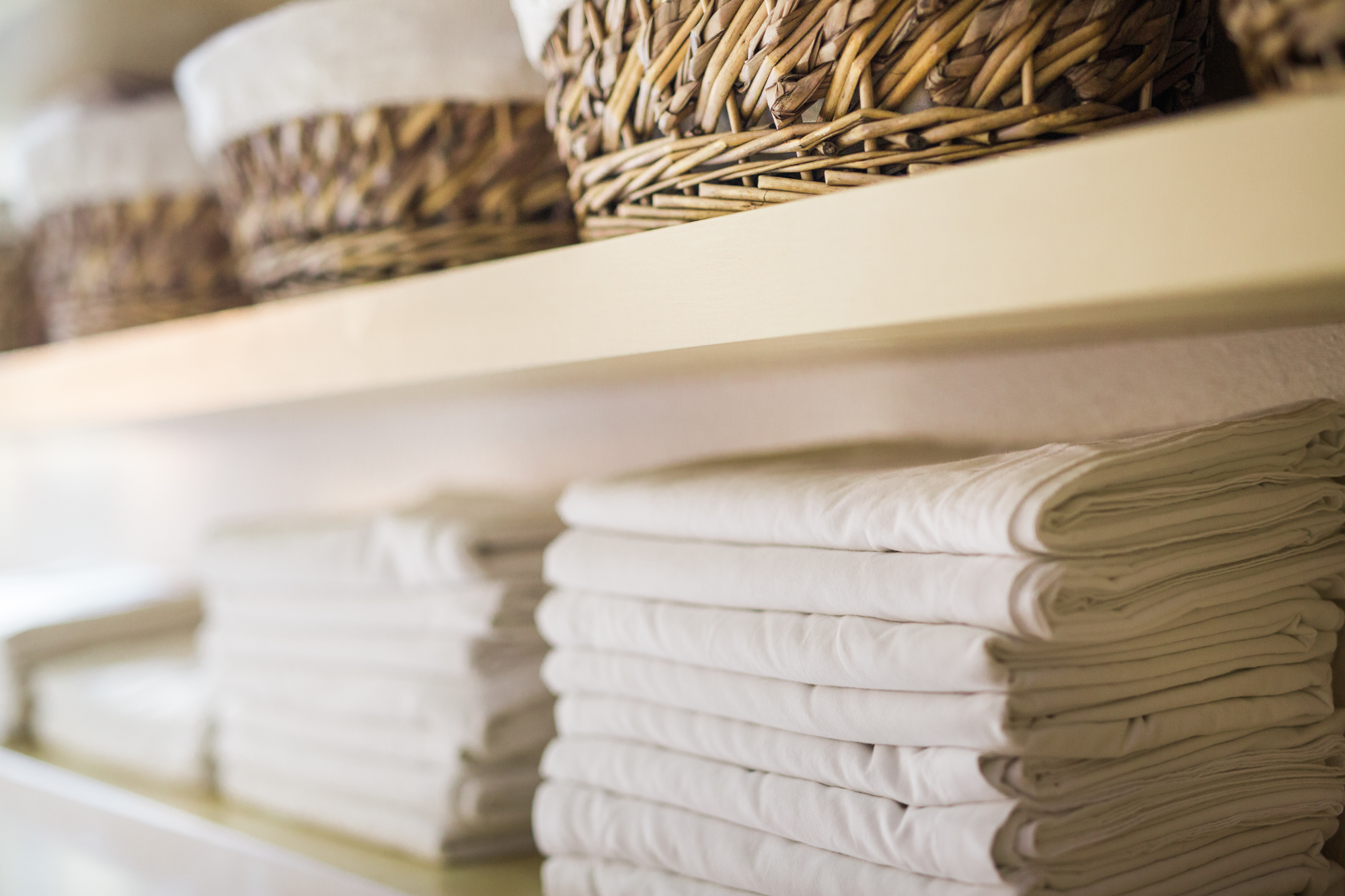  Images displays freshly laundered linens and towels, neatly stacked on shelves at Mantis Massage Austin Texas. Experience pristine comfort where every detail is meticulously cared for. Mantis Massage promises a hygienic and luxurious      massage ex