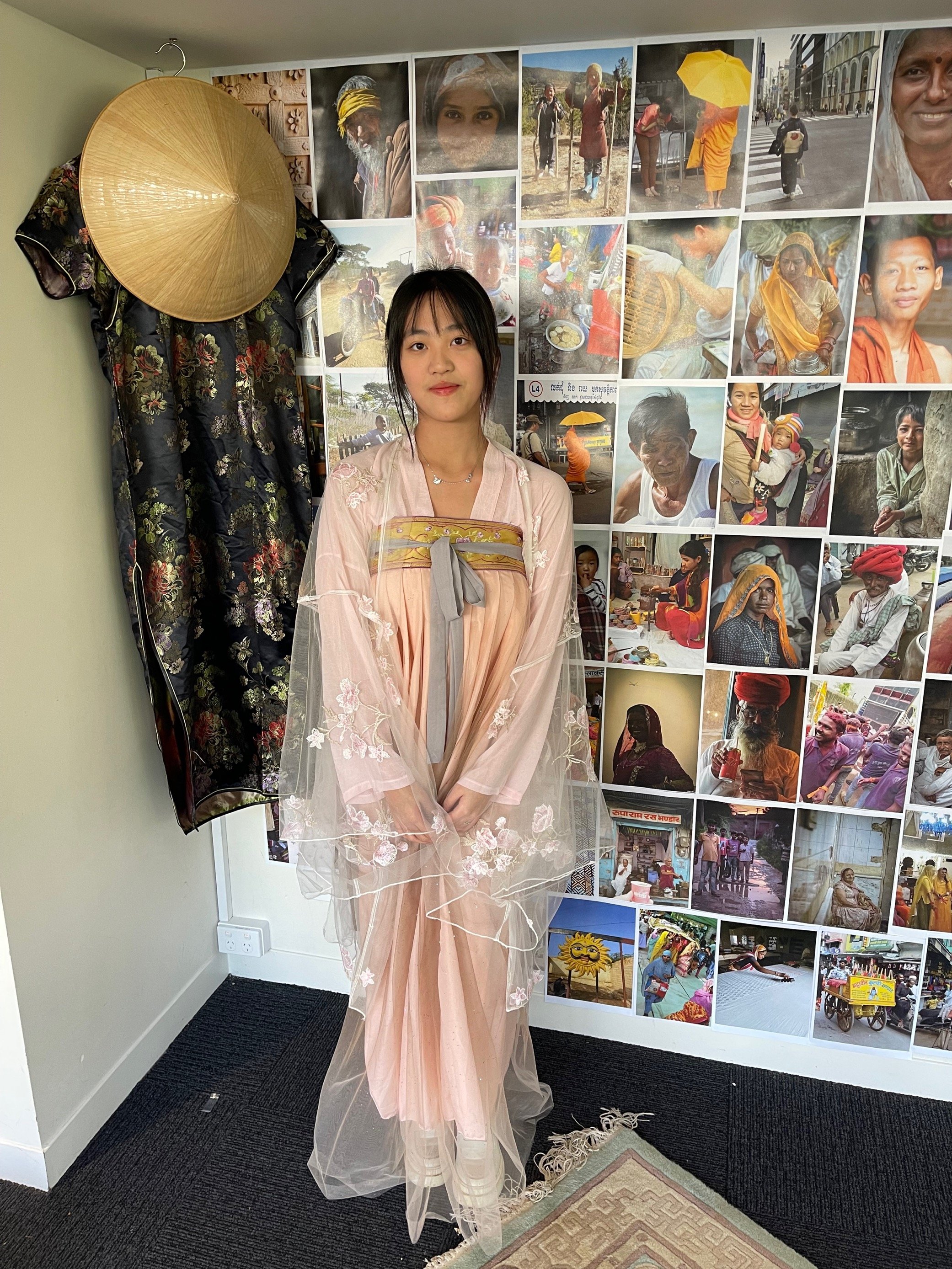 Jen Feng in her National dress in front of the global collage in the PAC.