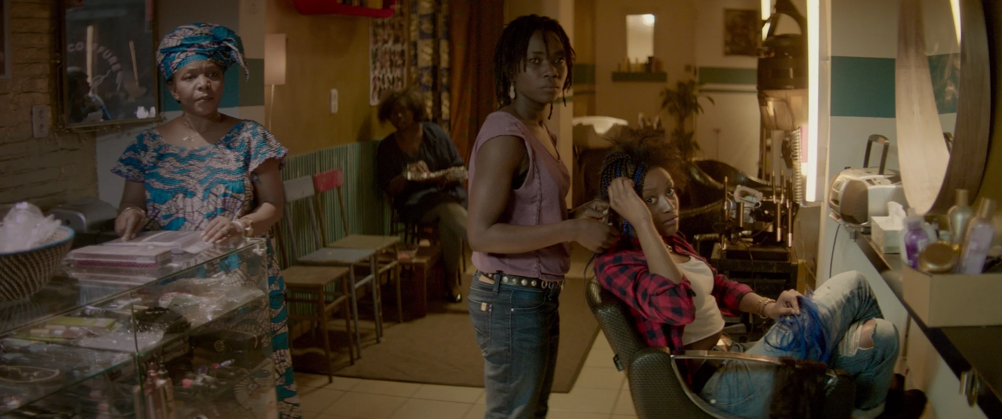 NKOSI COIFFURE de Frédérike Migom, 2015, fiction, 14' Dans une rue à Matonge, le quartier Congolaise à Bruxelles, Eva tente d'échapper à une dispute avec son petit ami en fuyant dans un salon de coiffure afro. Initialement elle est prise en charge par les femmes dans le salon, qui voient une femme en détresse. Mais quand nous découvrons la raison de la dispute, les opinions se divisent.