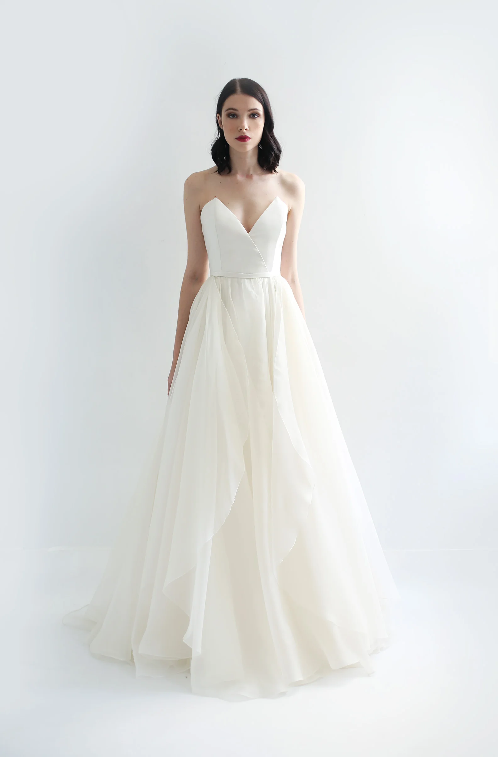  Ivory silk organza gown with strapless overlap V-neck bodice in silk twill . Full A-line skirt in silk organza with additional flounces for volume.. Fully lined in silk.