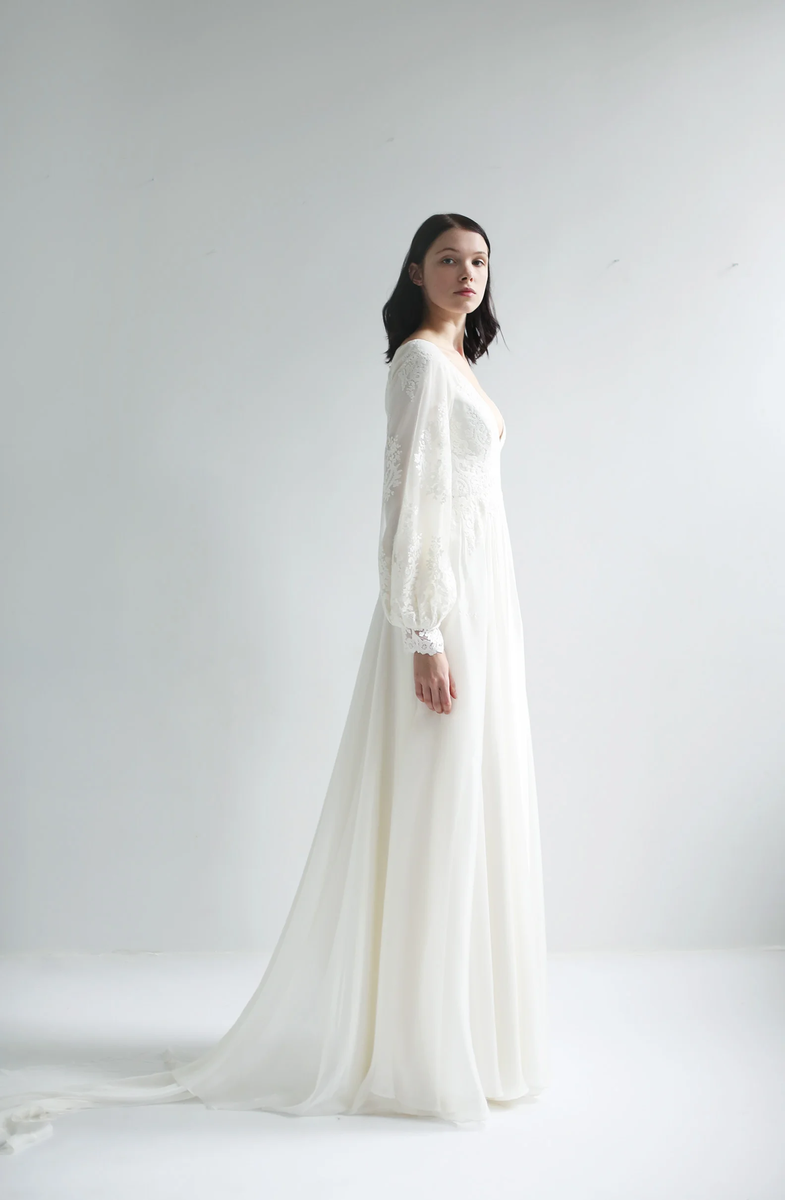 light ivory V-neck lace bodice gown with full lace lantern sleeves. Diamond keyhole lace back. A-line ivory featherweight chiffon skirt with slit. closes with zipper up the back.