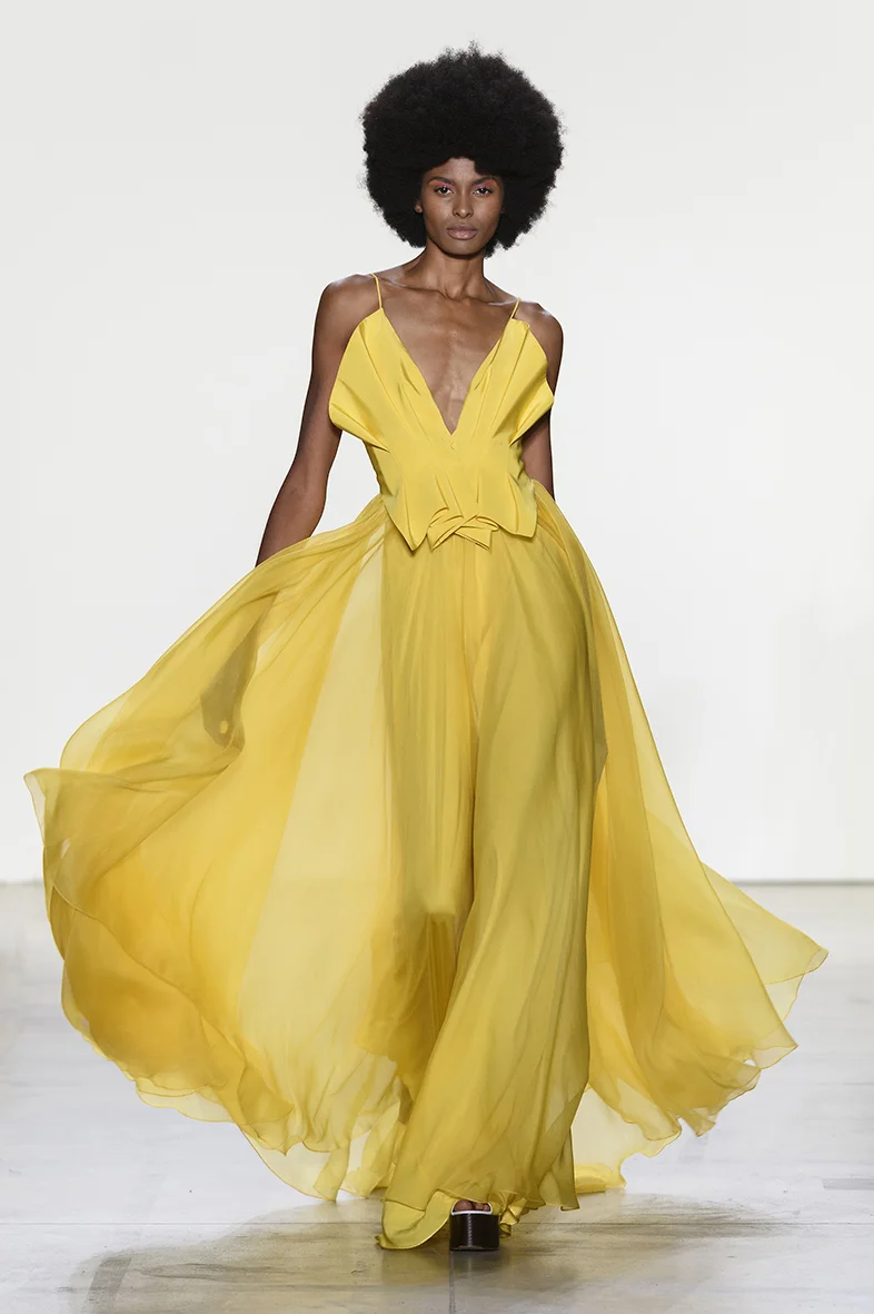 Yellow silk faille and organza gown with structured and pleated bodice detail. Wide open back with spaghetti straps. Full A-line skirt in silk organza