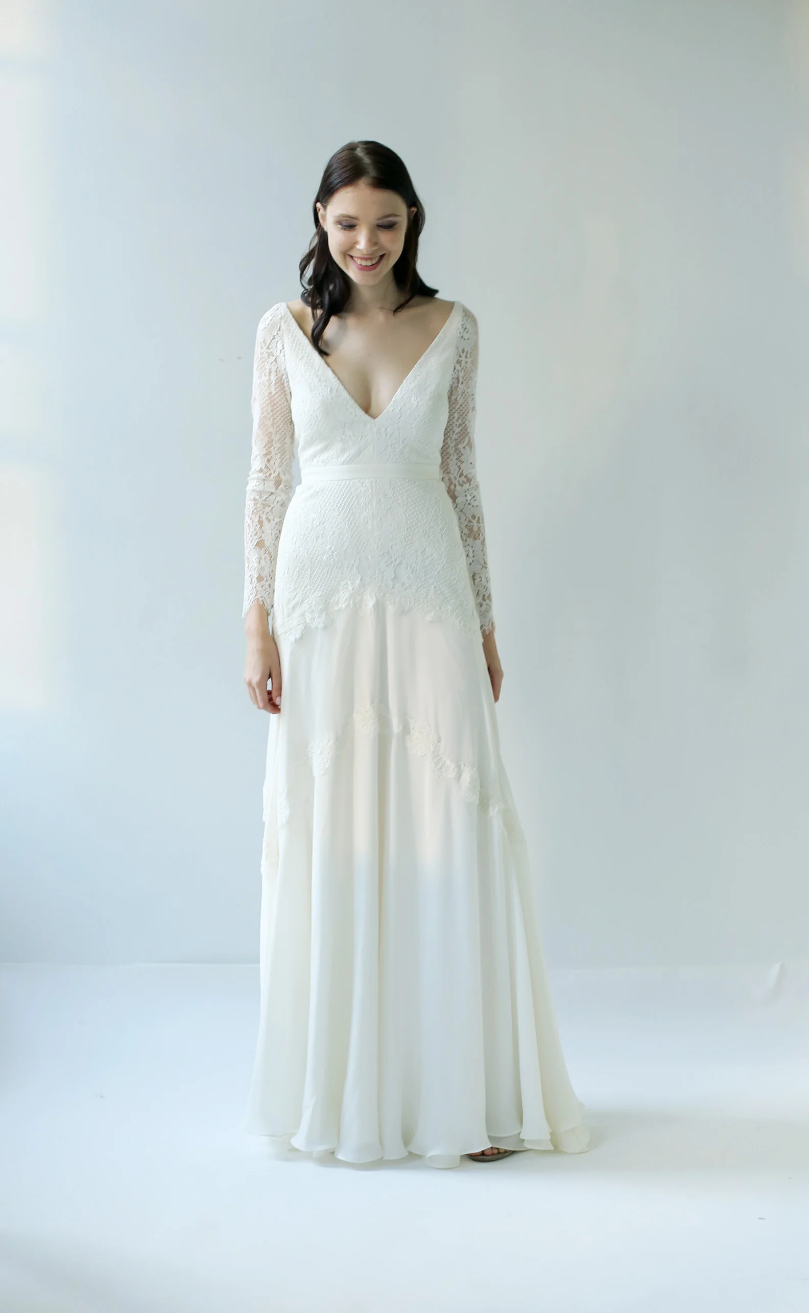 light ivory lace and silk chiffon with long lace sleeves. It has both a v-neck front and v-back. It is slim fitted through the hips into a 3 panel soft a-line skirt