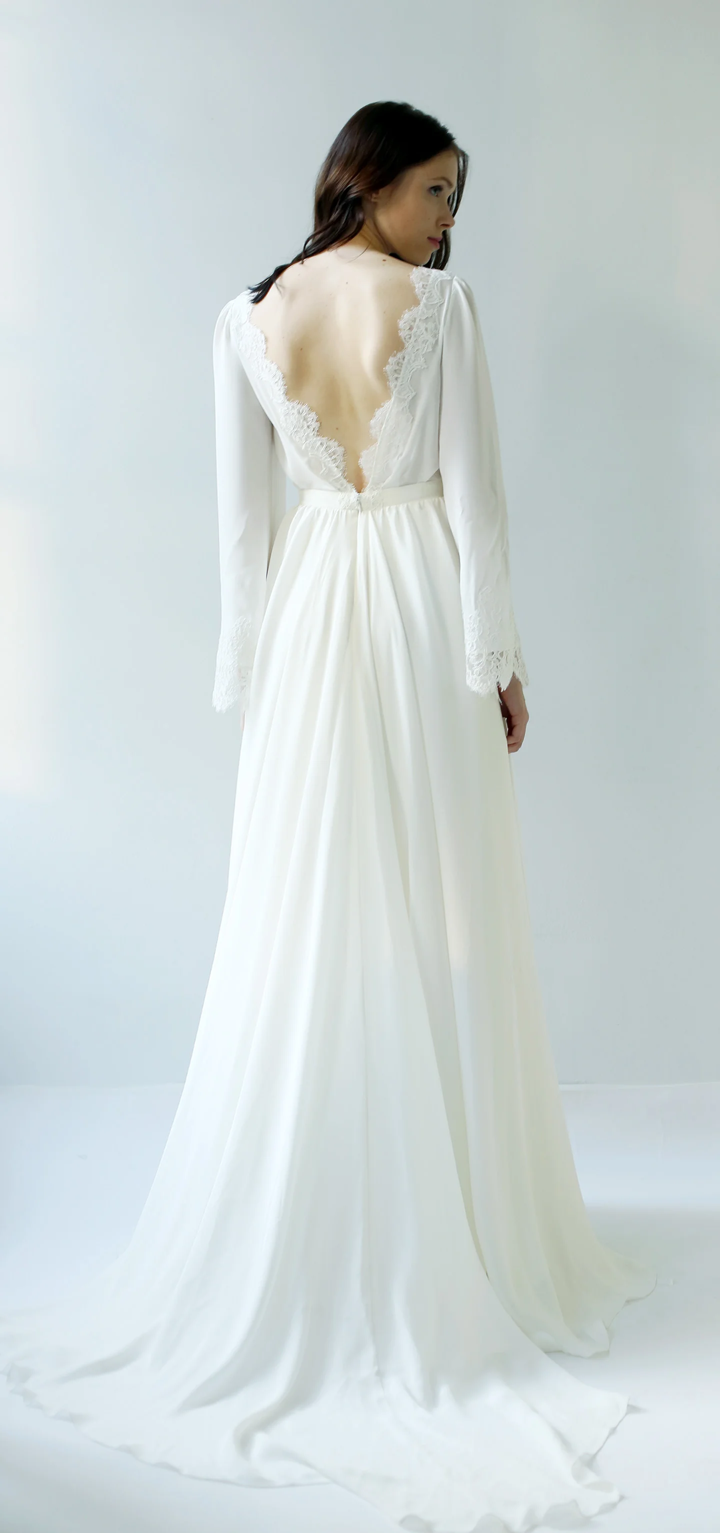 light ivory luxurious silk georgette gown with long full sleeves. Its deep v-neckline and back are covered and trimmed in French lace, and there is a lace scallop at the sleeve cuff.