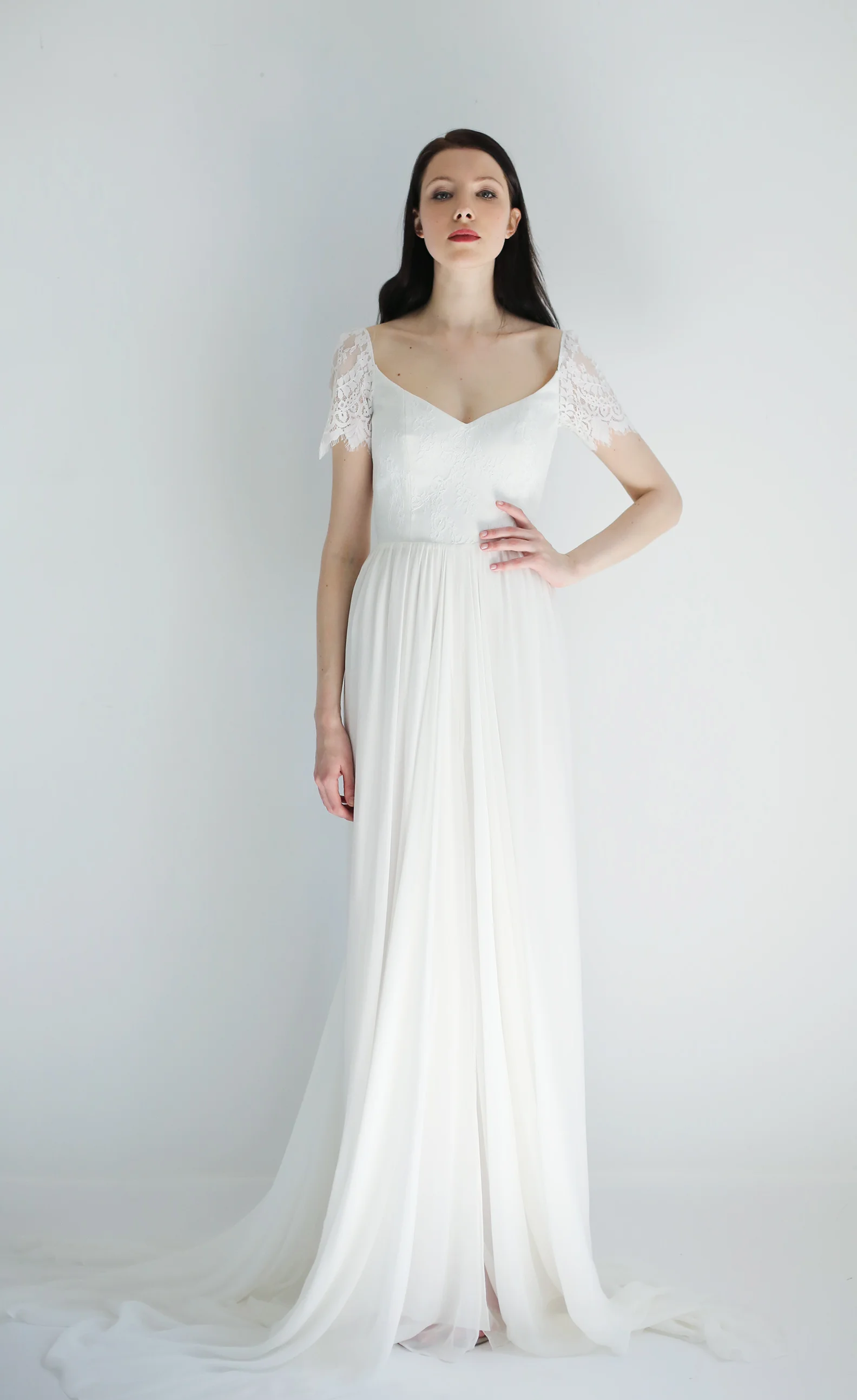 Copy of light ivory lace and silk gown with short sleeves. Bodice is a soft V front and low V back with boning. Skirt in ivory silk chiffon with train and slit opening at center front
