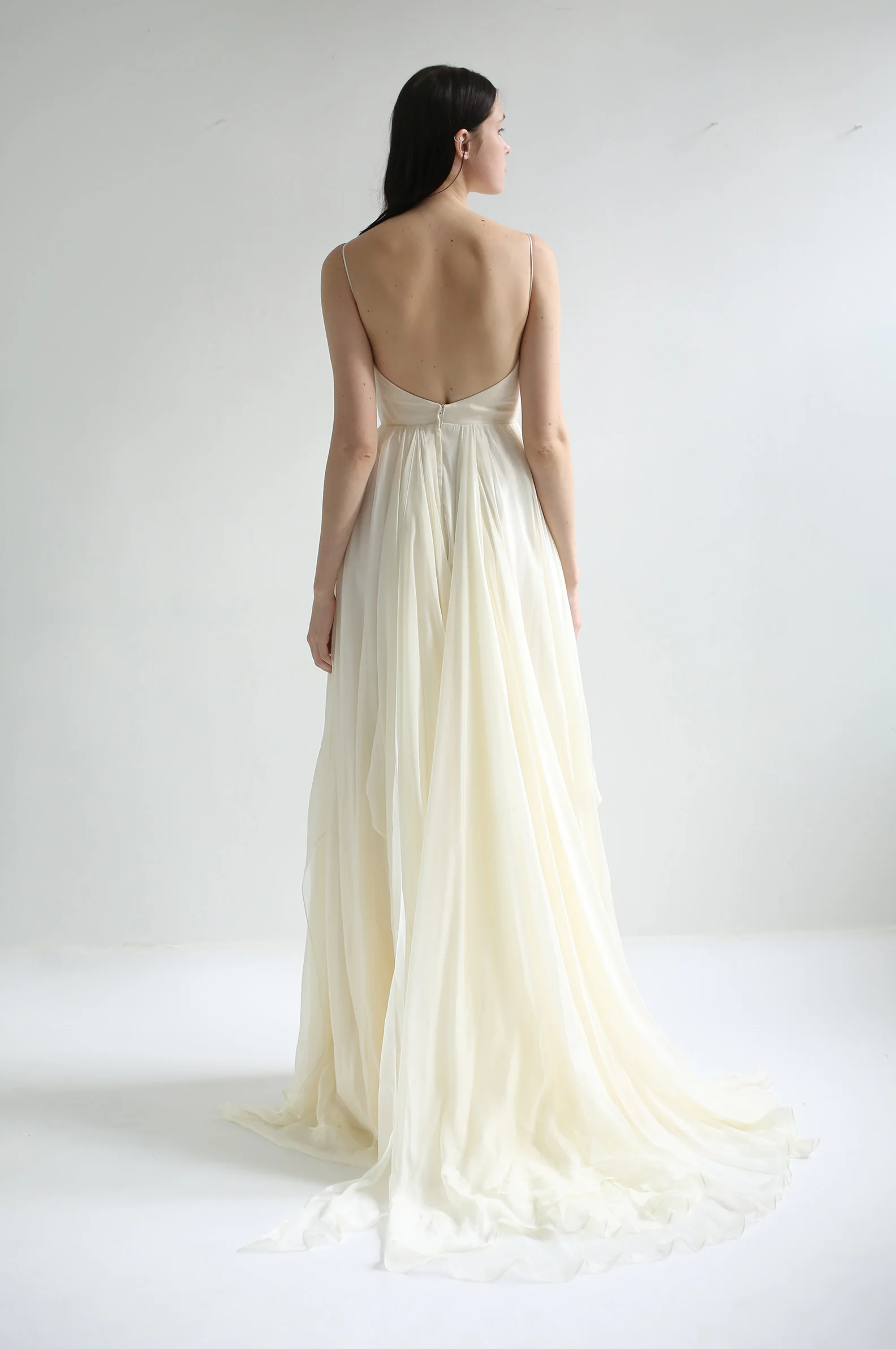  Fully boned curved -V bodice with spaghetti straps and V-plunge in the back. Skirt is made of assymmetrically draped high quality, feather-light silk chiffon in ivory