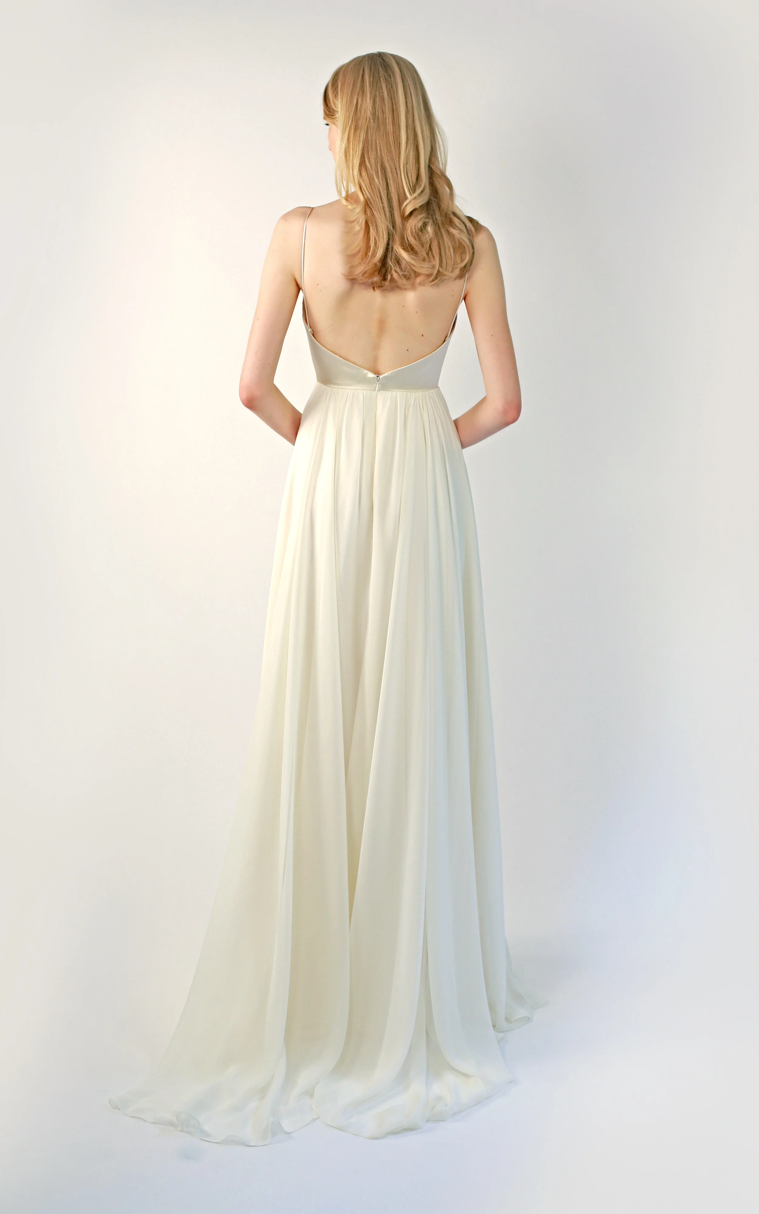 Copy of curved-v bodice with spaghetti straps in champagne silk duchess satin. It is fully boned and the top is lined with a V-dip back. The skirt is a full circle