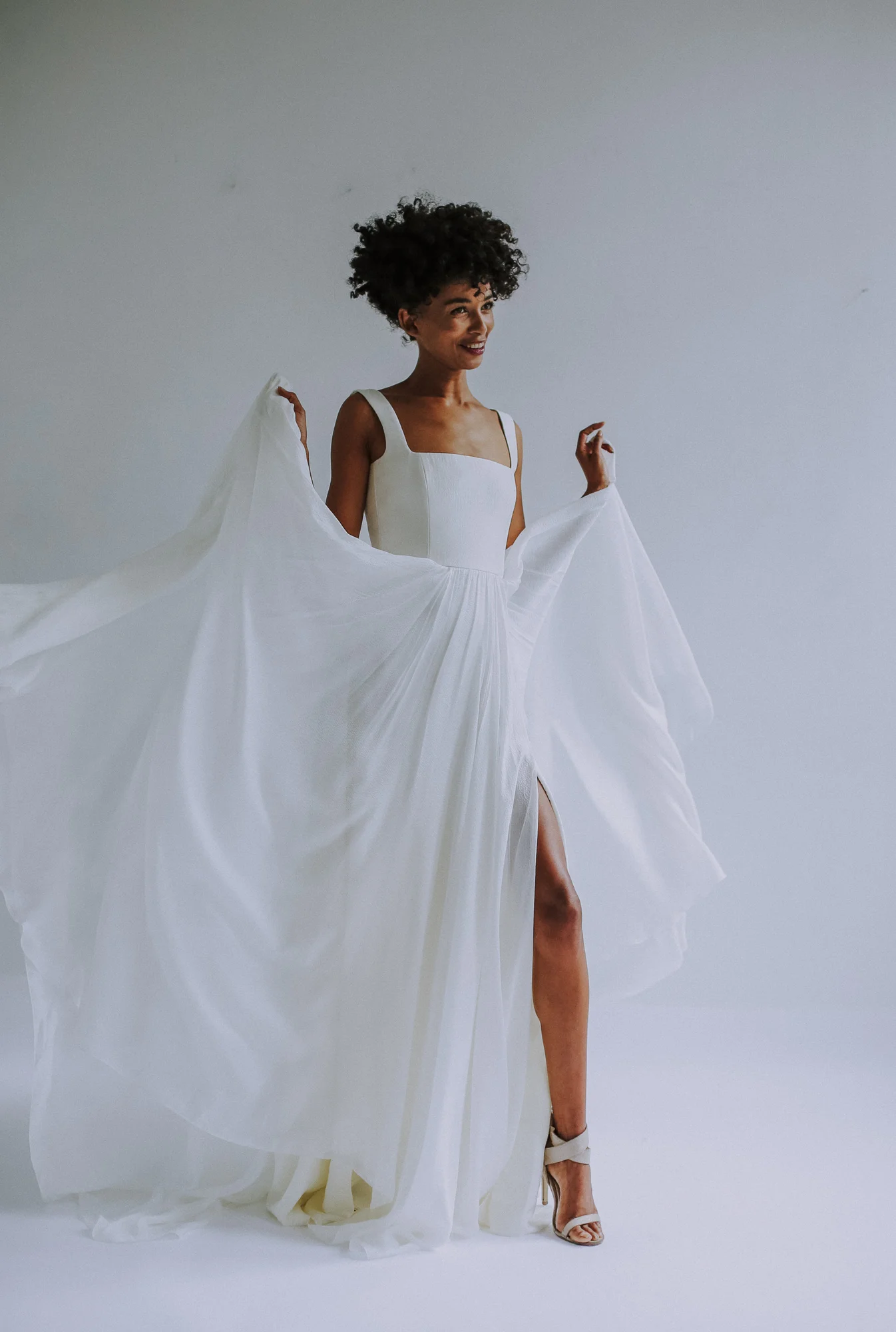 light ivory square neck bodice gown in rich, hammered silk chiffon. Fully boned bodice, full-A- line skirt with side slit and train. Low, squared back. Closes with zipper up the back.