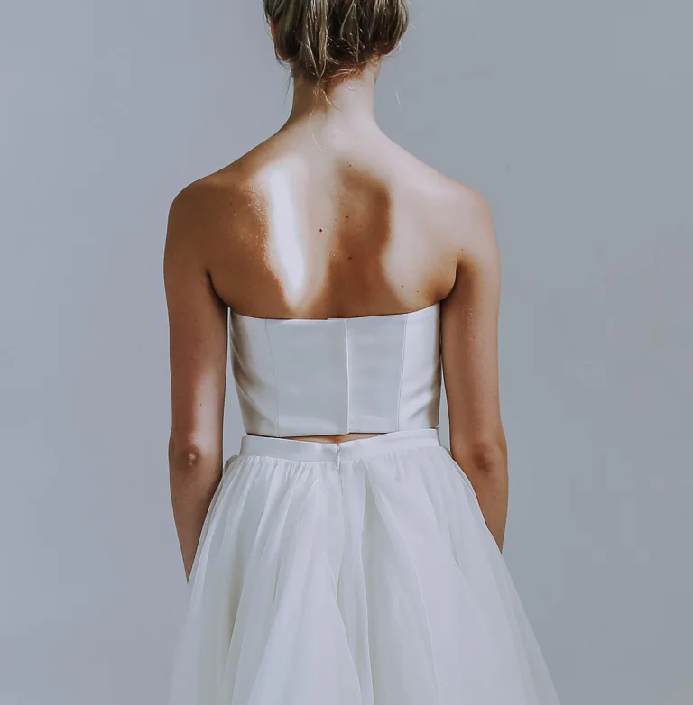 Gorgeous straight across cut neckline with a subtle downward curve toward sides/back. Fully lined in silk with boning, and fused to hold securely in place