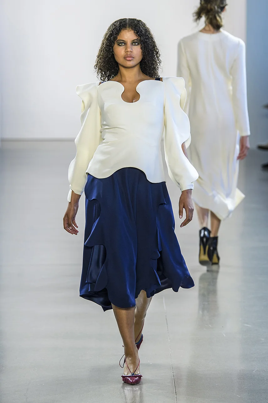 Ivory wool crepe top with wave neckline and scalloped tie sleeves. Fully lined, fitted top shaped with darts. Hook/eye closure up back.