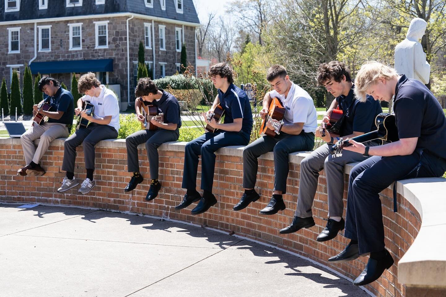 Strumming into spring! 🎸   Mr. Muller&rsquo;s Guitar I class took advantage of the sunny weather with an outdoor session, and even Fr. Murray couldn&rsquo;t resist stopping by to enjoy the music!