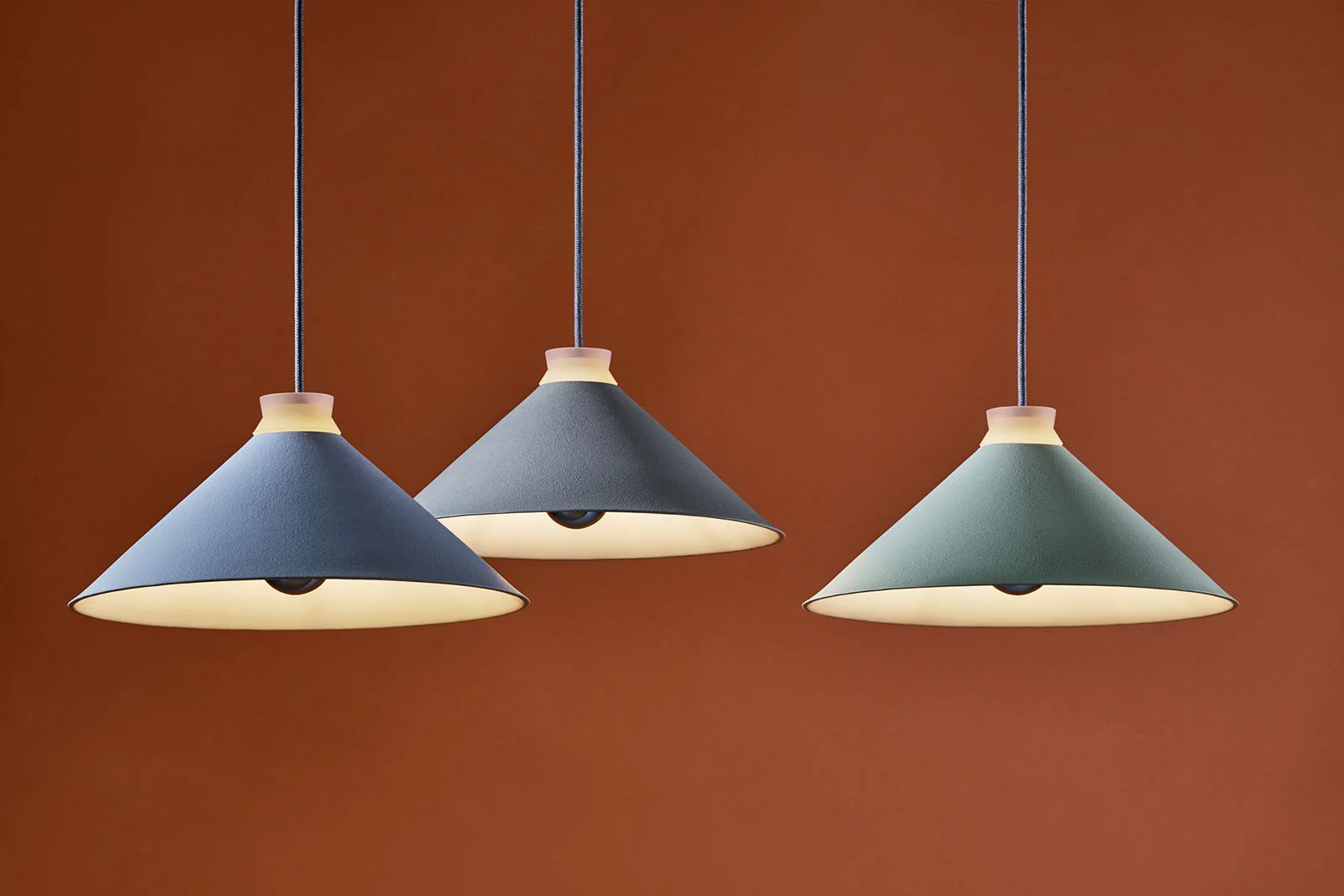Designed for the London-based lighting studio Hand & Eye we developed the Fuji lamp. We explored our interest in combining traditional hand craft techniques with modern industrial mass production methods. The central focus was the silicone, which holds the light bulb and ceramic together, and gives off a beautiful warm glow when illuminated. The shade is made of porcelain with a textured engobe finish. A simple classic design with a modern twist.