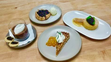 Italian desserts starting from the top: Blueberry crostada with olive oil gelato, olive oil polenta cake with fig compate, pine nut tart with creme fraiche and candied orange peel, and chocolate budino with salted caramel, whipped cream and shortbread cookies with cherry compote