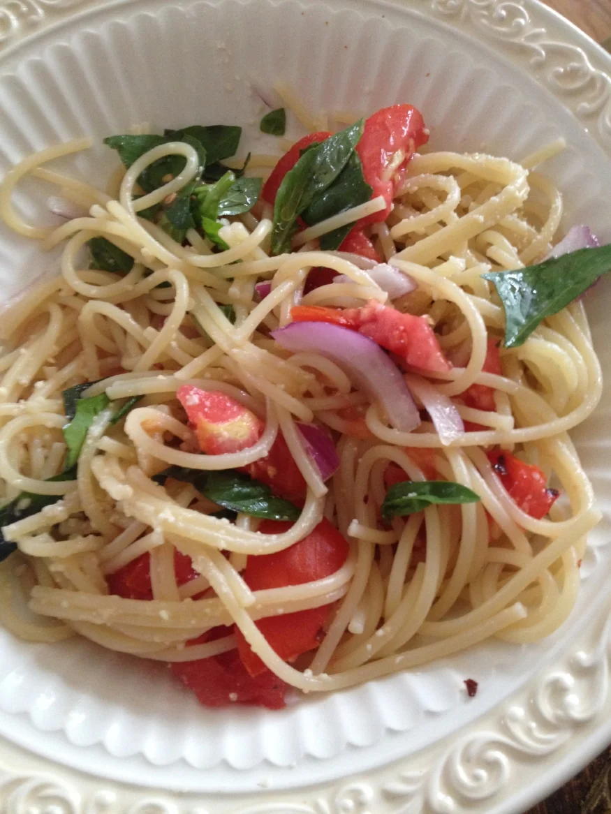 Spaghetti with tomatoes, basil, and red onion