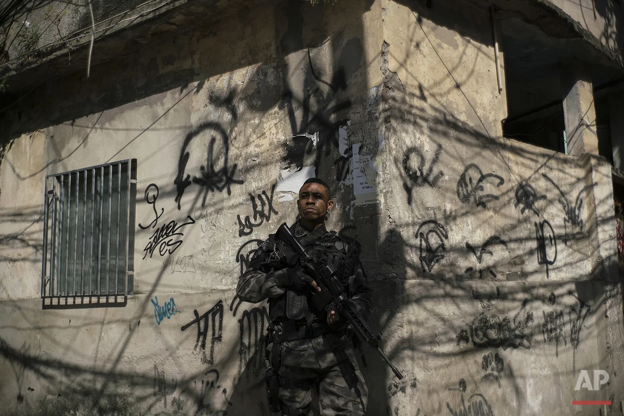 In this June 29, 2016 photo, a police officer takes position during an operation against drug traffickers at the "pacified" Jacarezinho slum in Rio de Janeiro, Brazil. The number of people killed by police has spiked in the past two years after dropping significantly the previous six. Overall murders are also on the rise in the first half of 2016, just as officials wanted to use the Aug. 5-21 Olympic Games to showcase the city as a tourist destination. (AP Photo/Felipe Dana)