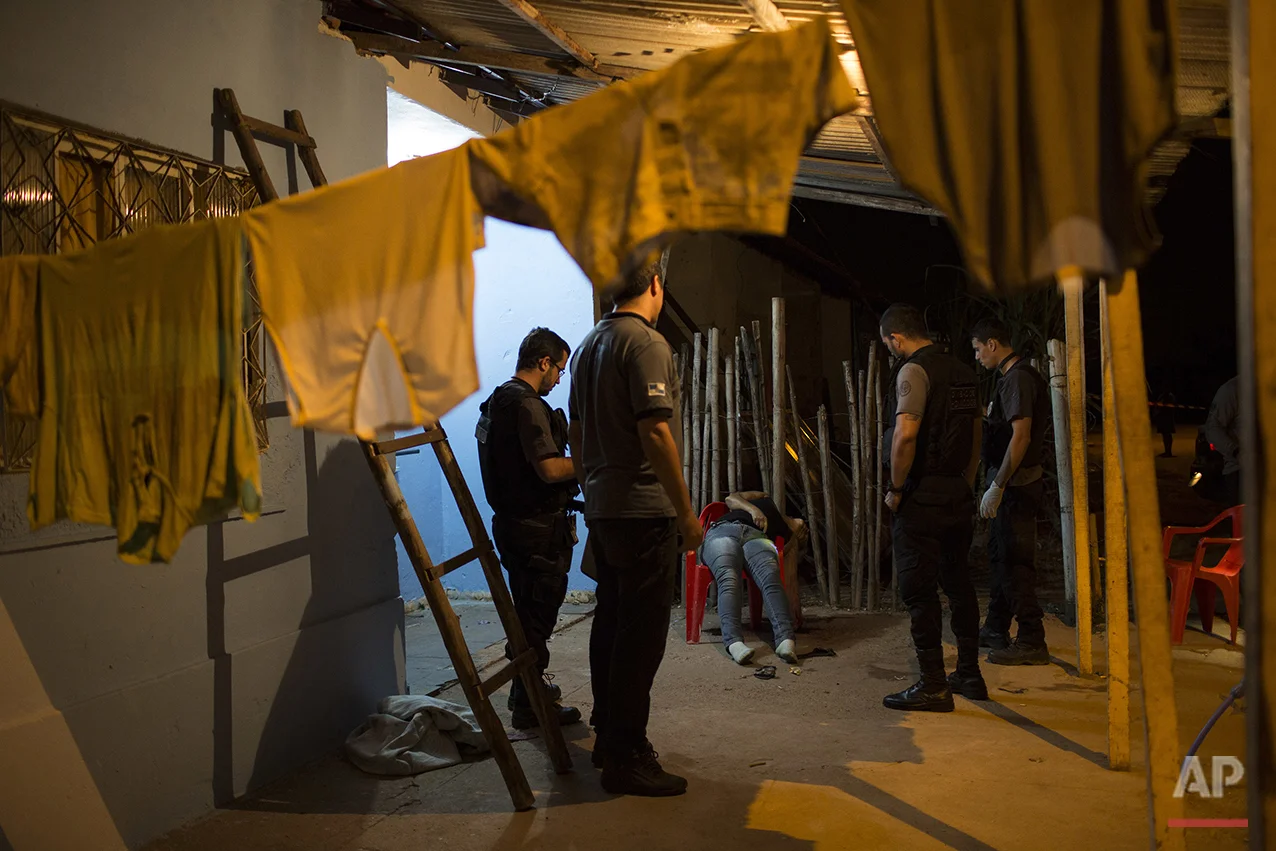 In this July 13, 2016 photo, police investigate the crime scene where Aga Lopes Pinheiro, a pre-candidate for local council, was shot dead in Mage, in greater Rio de Janeiro, Brazil. According to local news reports the 49-year-old was shot by four gunmen while in a bar with a friend and her partner. Lopes is the 11th politician murdered in the greater Rio area since November. Police have not been able to determine the motives for the killings. (AP Photo/Felipe Dana)