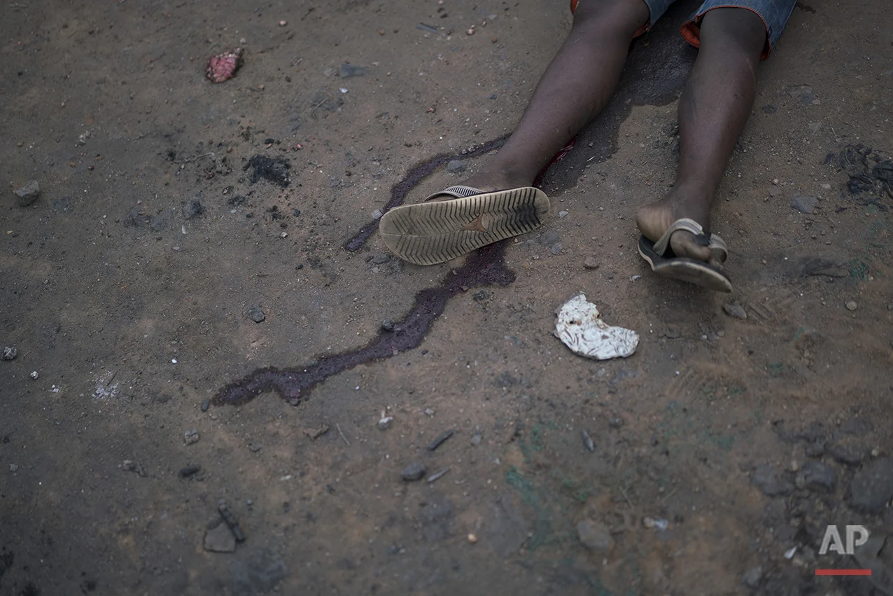 This June 30, 2016 photo shows the body of a teenage boy who was killed while walking outside of his home turf in a gang controlled area of Rio de Janeiro, Brazil. Later in the day, according to residents, the father went to denounce his son's death to the gang and was shot dead. Overall murders are on the rise in the first half of 2016 say officials, and the victims are overwhelmingly young, black men. (AP Photo/Felipe Dana)