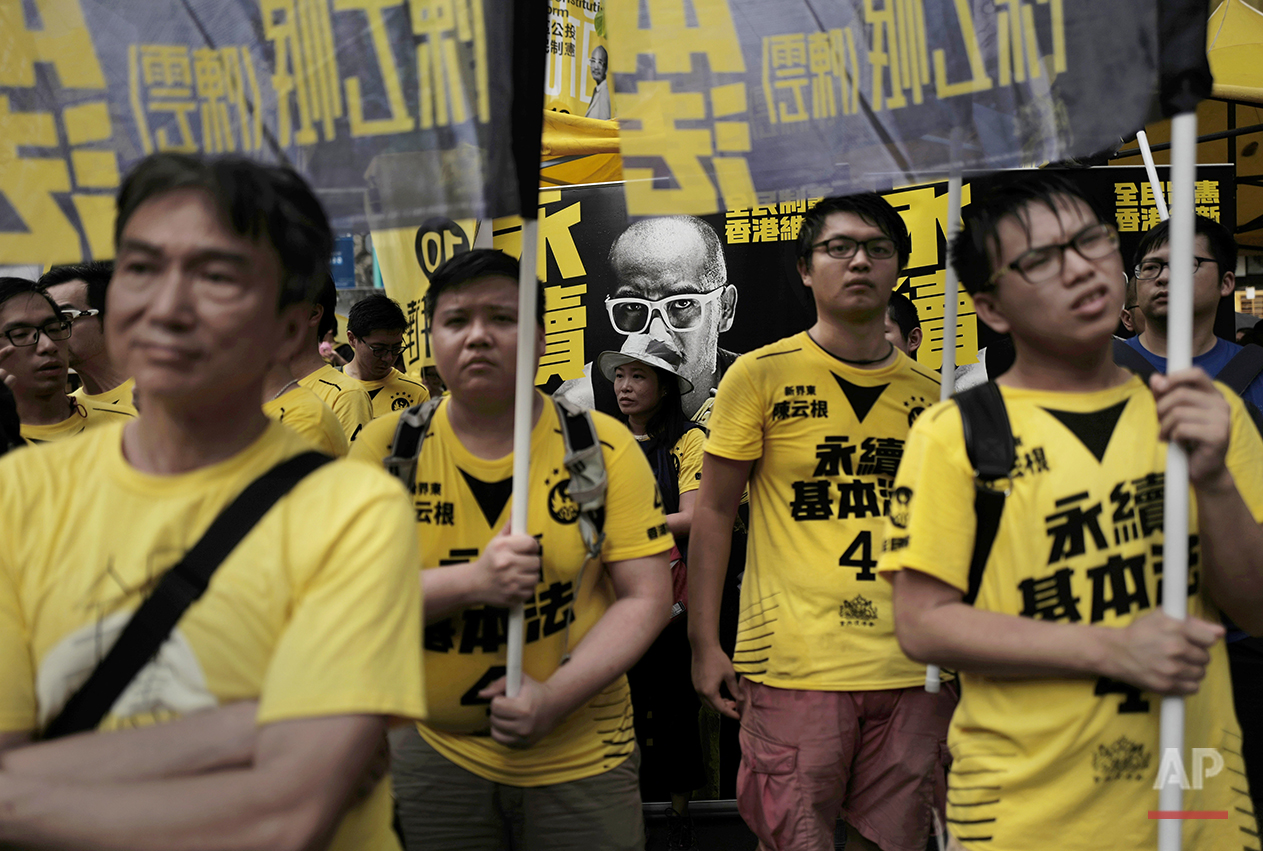  In this Aug. 27, 2016 photo, supporters of radical localist group Civic Passion hold banners in front of a photo of candidate Wong Yeung-tat at a pre-election rally in Hong Kong. (AP Photo/Vincent Yu) 