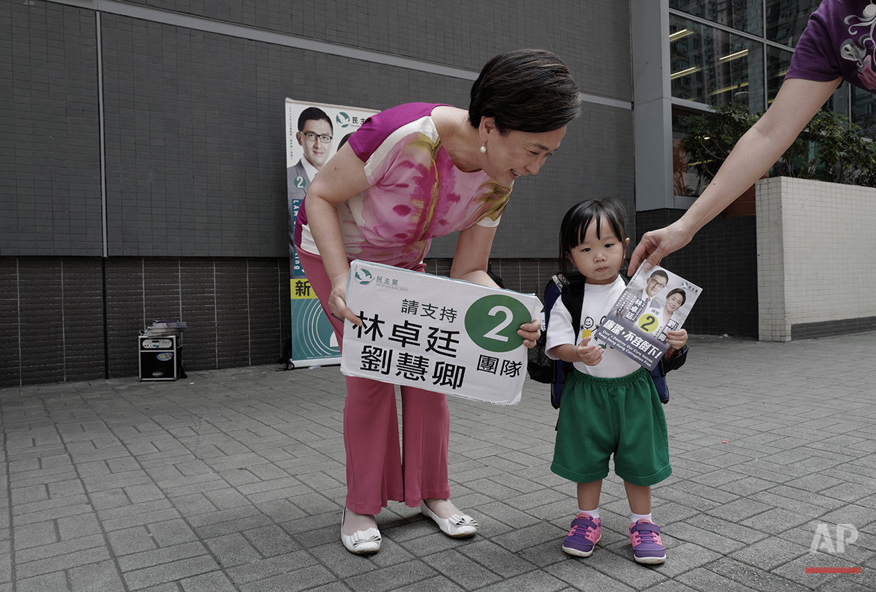  In this Wednesday, Aug. 24, 2016 photo, Hong Kong pro-democracy lawmaker, Emily Lau talks to a girl during a election campaign in Hong Kong. After two decades as a pro-democracy lawmaker, Emily Lau expects to step down as she and other party veteran