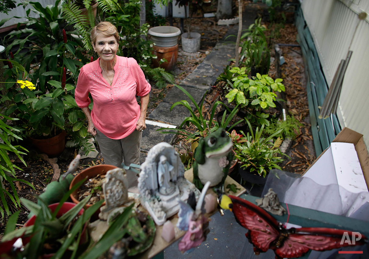  In this Tuesday, July 12, 2016 photo, Nelly Shirley, 74, poses outside of her mobile home at the Little Farm trailer park in El Portal, Fla. She received a Beautification Award for creating the lush, tropical garden around her mobile home where she 