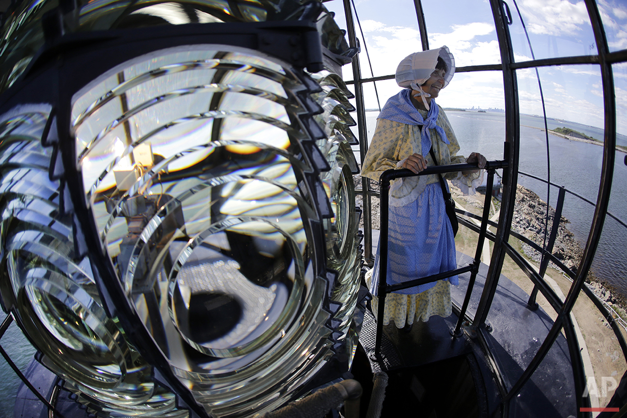  In this Aug. 17, 2016 photo, Sally Snowman, the keeper of Boston Light, looks out from the lantern room while standing next to the Fresnel lens, on Little Brewster Island in Boston Harbor. (AP Photo/Elise Amendola)&nbsp;See these photos on  APImages