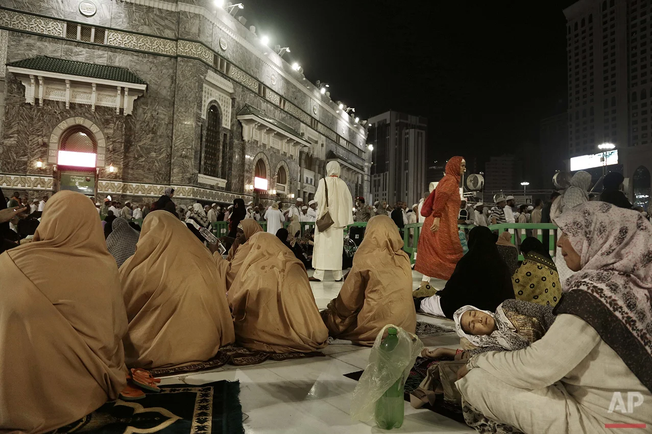  A Muslim woman from Kyrgyzstan, right, sleeps after the Fajr prayer before sunrise, outside the Grand Mosque in the Muslim holy city of Mecca, Saudi Arabia, Thursday, Sept. 8, 2016. Muslim pilgrims have begun arriving at the holiest sites in Islam a