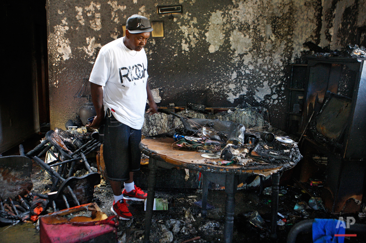 Frederick Terrell looks inside the home where an early morning fire killed multiple people, including children, Monday, Sept. 12, 2016, in Memphis, Tenn. Terrell said he is a friend of the family that lived in the home. (AP Photo/Karen Pulfer Focht)