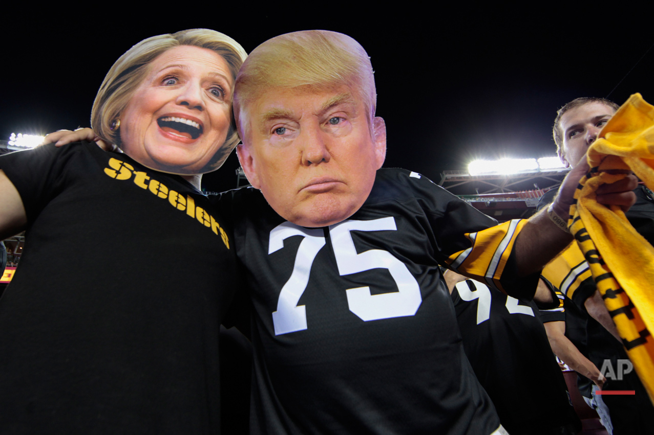  Pittsburgh Steelers fans Brian Picchini (left) and Rusty Kuchta (right) wear presidential candidates Sec. Hillary Clinton and Donald J. Trump masks during the first half of an NFL football game against the Washington Redskins in Landover, Md., Monda