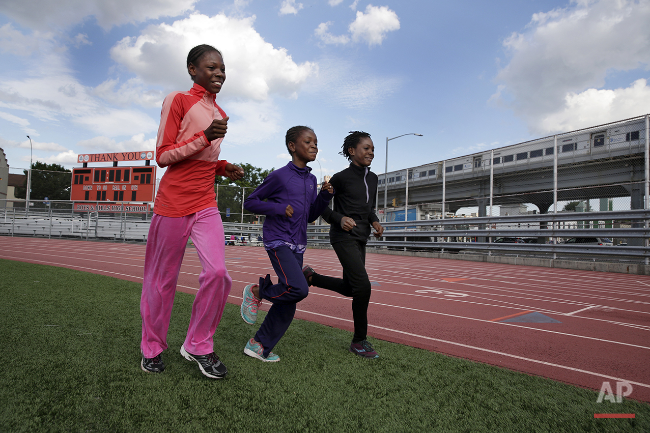  In this July 11, 2016 photo, Tai Sheppard, 11, Brooke Sheppard, 8, and Rainn Sheppard, 10, left to right, run warm-up laps at Boys and Girls High School, in the Brooklyn borough of New York. Every morning, the three young sisters wake up together wi