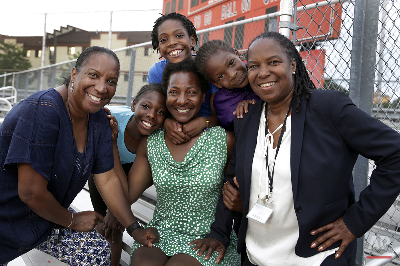  In this July 11, 2016 photo, Tonia Handy, 46, seated center, is surrounded by her children, Tai Sheppard, 11, Rainn Sheppard, 10, and Brooke Sheppard, 8, left to right, and flanked by coaches Karel Lancaster, left, and Jean Bell, right, after track 