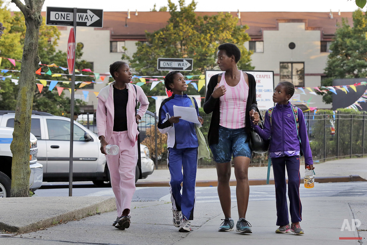 In this July 12, 2016 photo, Tonia Handy, 46, is surrounded by her children, Tai Sheppard, 11, Rainn Sheppard, 10, and Brooke Sheppard, 8, left to right, walk home after track workouts at Boys and Girls High School, in the Brooklyn borough of New Yo