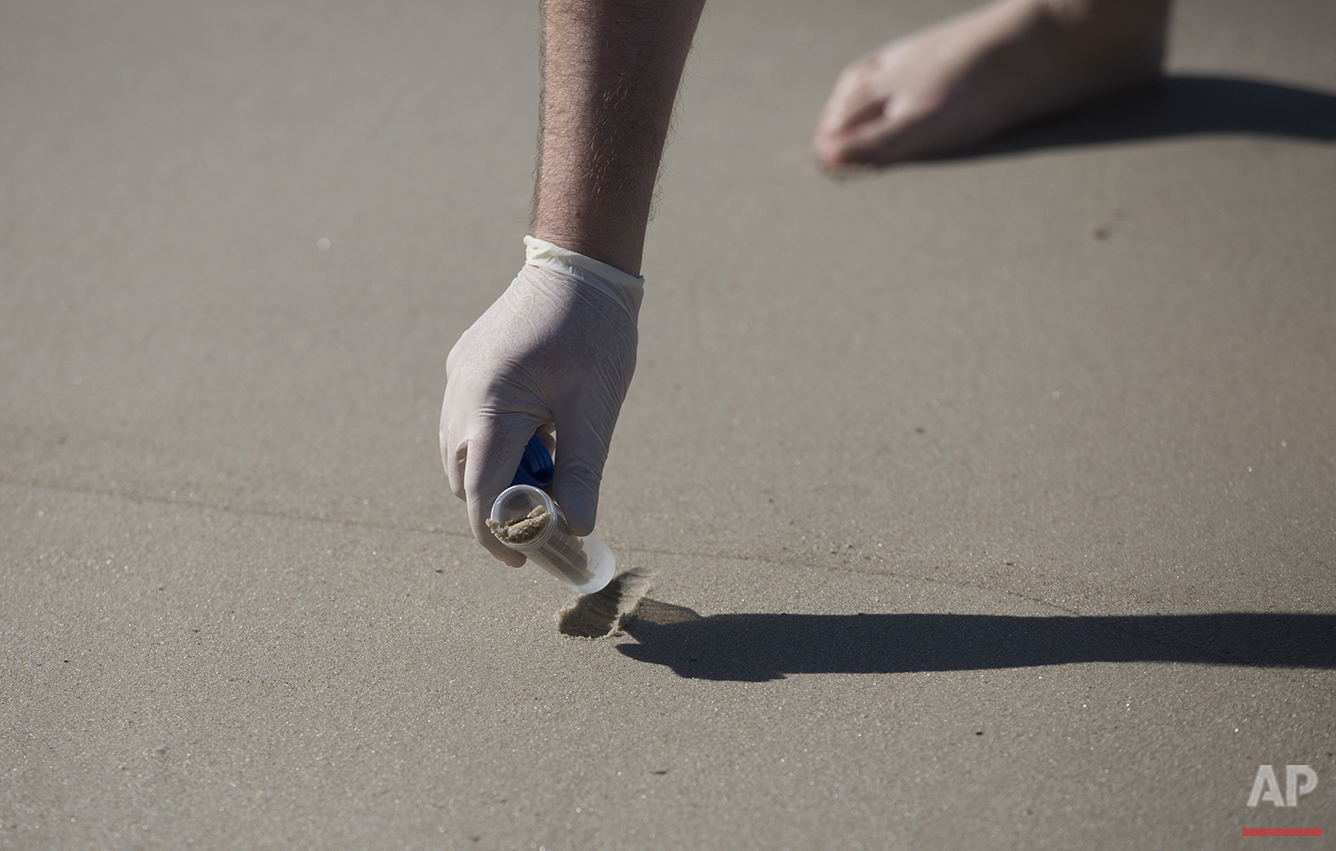  In this July 11, 2016 photo, doctoral candidate Rodrigo Staggemeier collects sand from Copacabana Beach for a study commissioned by The Associated Press in Rio de Janeiro. Samples from Copacabana and Ipanema revealed high levels of viruses, which re