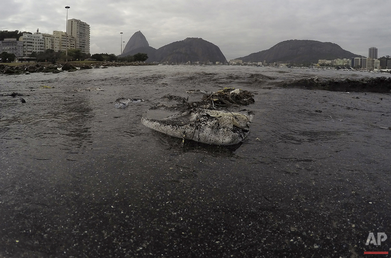  Thrash floats on the water of Botafogo beach next to the Sugar Loaf mountain and the Guanabara Bay where sailing athletes will compete during the 2016 Summer Olympics in Rio de Janeiro, Saturday, July 30, 2016. (AP Photo/Leo Correa) 