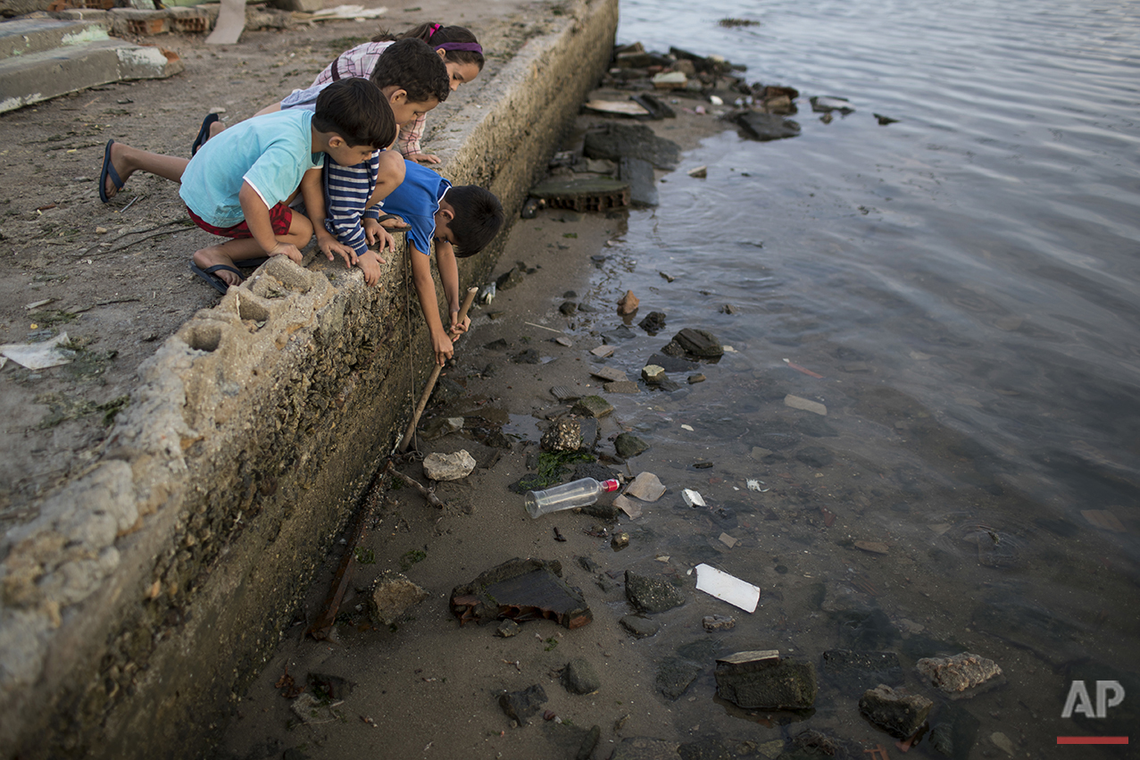  Children try to catch a crab as they play on the polluted shore of Guanabara Bay in Rio de Janeiro, Saturday, July 30, 2016. In Rio, the main tourist gateway to the country, a centuries-long sewage problem that was part of Brazil’s colonial legacy h