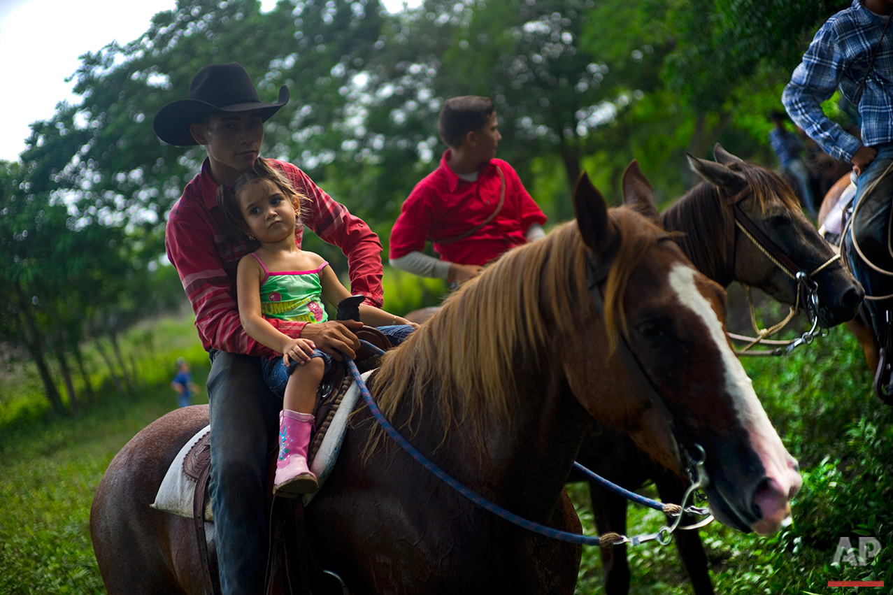  In this July 29, 2016 photo, cowboys watch an improvised rodeo event at a farm in Sancti Spiritus, central Cuba. In the Cuban countryside, many children learn to ride a horse before they learn to ride a bicycle. (AP Photo/Ramon Espinosa) 