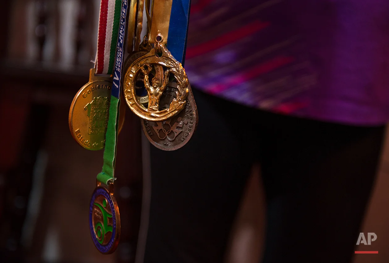  In this July 21, 2016 photo Graciela Sanchez Martinez shows off a collection of Para-rodeo and basketball medals garnered by her husband Salvador Espinoza over 10 years ago, at their home in Chalco, Mexico. Sanchez Martinez and her husband, who met 