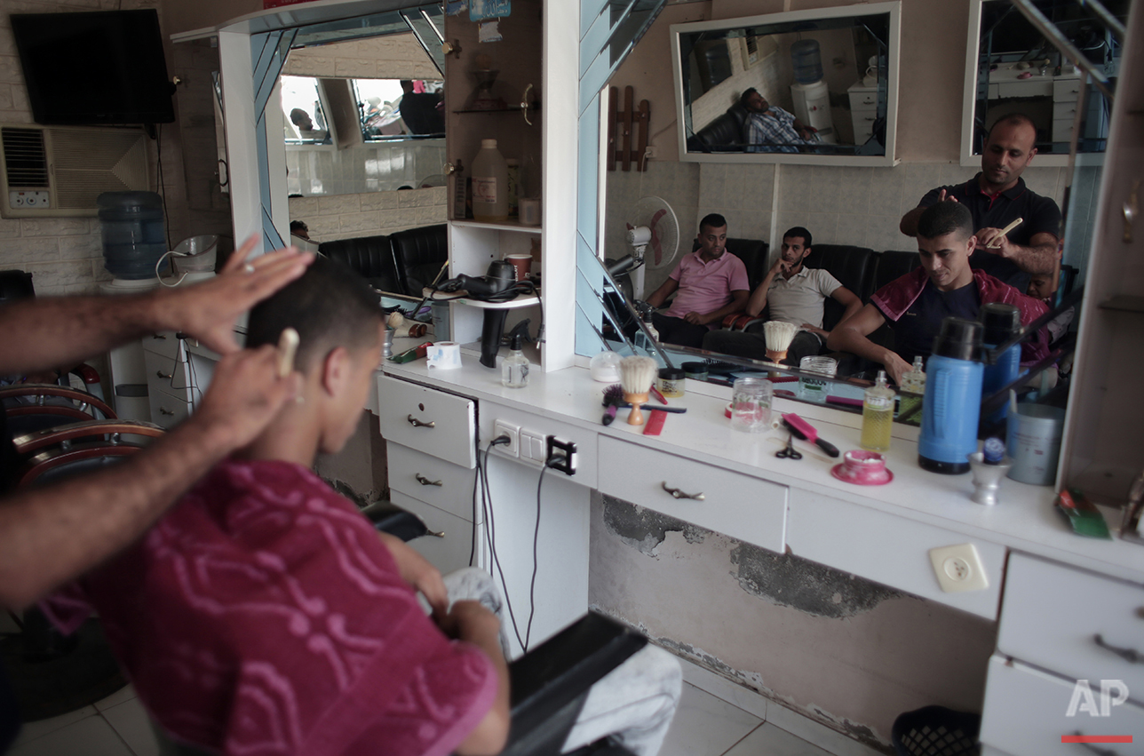  In this Saturday, July 31, 2016 photo, Palestinian groom Saed Abu Aser has a haircut while preparing himself for his wedding party in Gaza City. (AP Photo/ Khalil Hamra) 