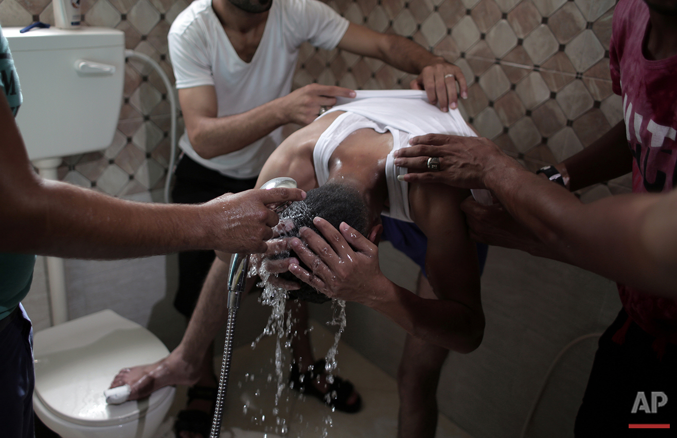  In this Saturday, July 31, 2016 photo, friends of Palestinian groom Saed Abu Aser give him a bath in the family house as a tradition preparing him for his wedding in Gaza City. (AP Photo/Khalil Hamra) 